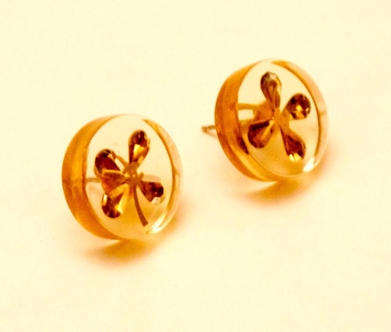 Vintage Chanel Clear Clover Charm Pierced Earrings from the 1980's. Remarkable pair of earrings that are in great condition for their age. They are a clear plastic with gold toned clovers on the inside. The actual earrings themselves are designed