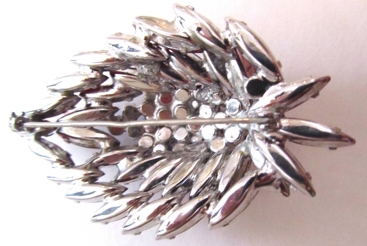 Magnificent unsigned Julianna Feather design pin. Done mostly in thin marquis shape stones that are ruby red. The stones are exquisite and are highlighted by the aurora stones in the center. The pin is 3 inches long. The pin is 1.75 inches high.