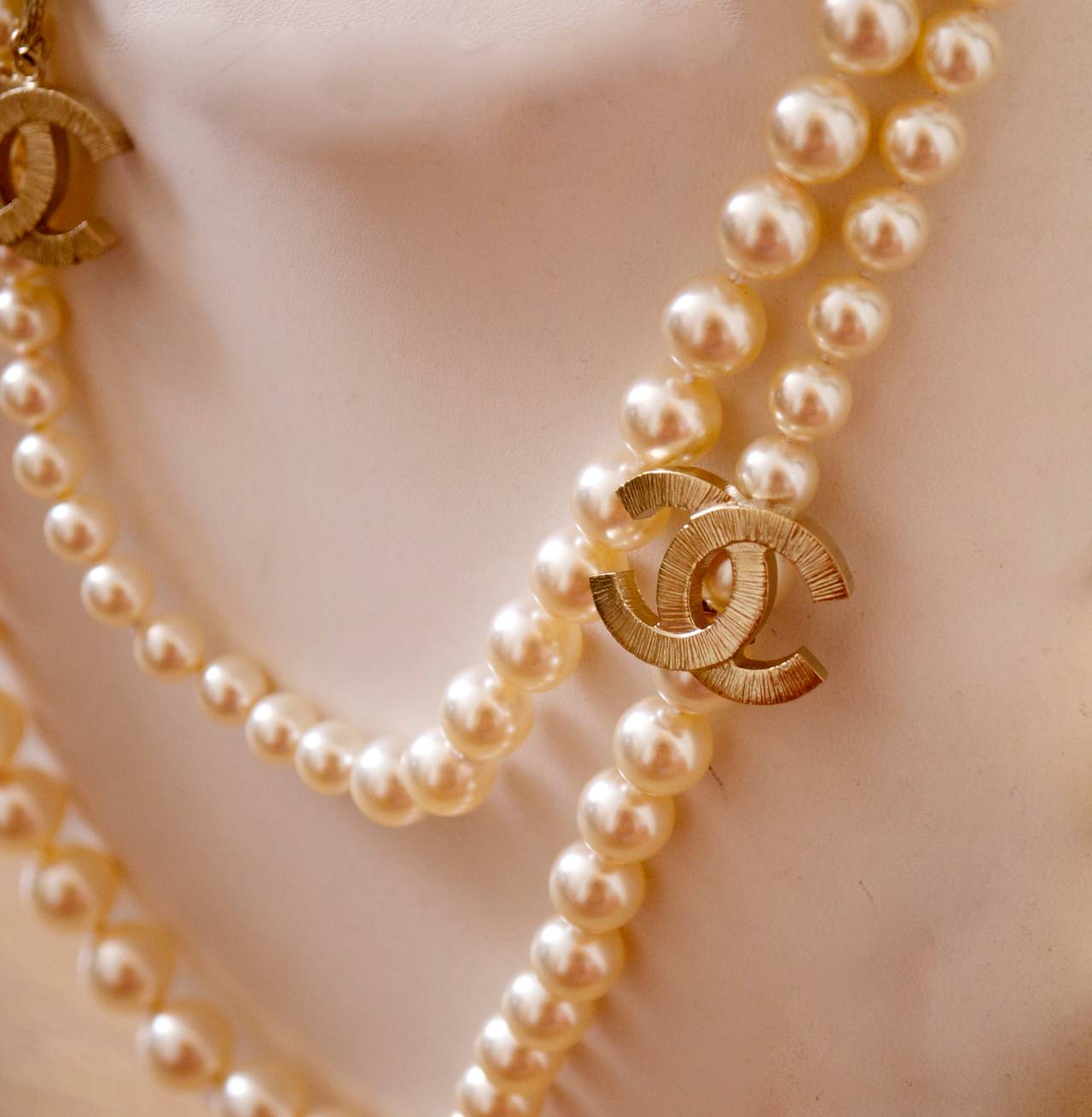 Spectacular pearl necklace by Chanel. 42 inches long with two CC logo charms along the strand. The pearls have graduated sizings along the strand with the two significant CC logo charms along the strand. There is a chain and clasp enclosure at the