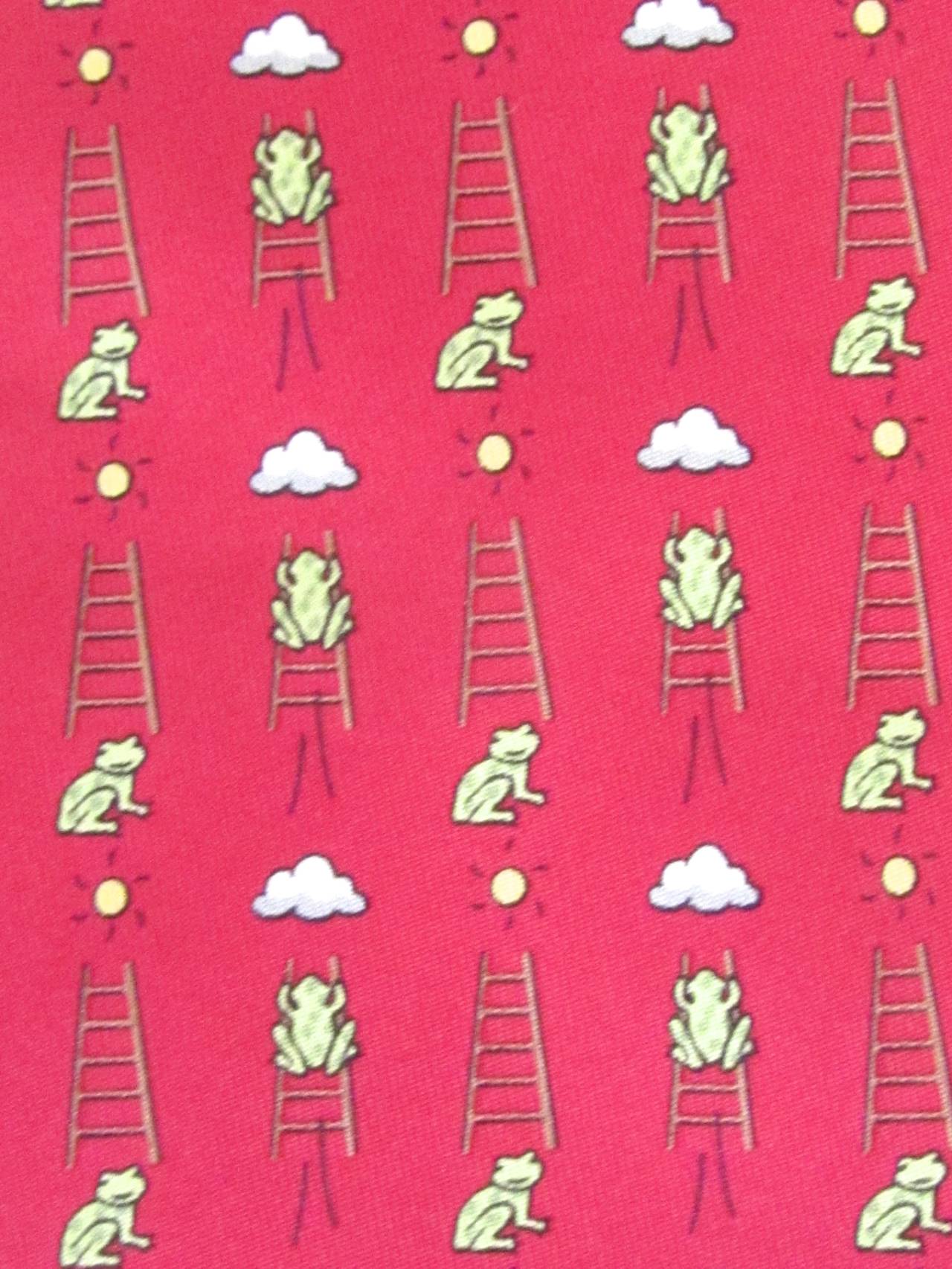 Hermes silk necktie. Tie is made in France and has a red background with images of frogs climbing ladders. Tie is in excellent condition and is from the 1990's. Fantastic addition to any personal tie collection.