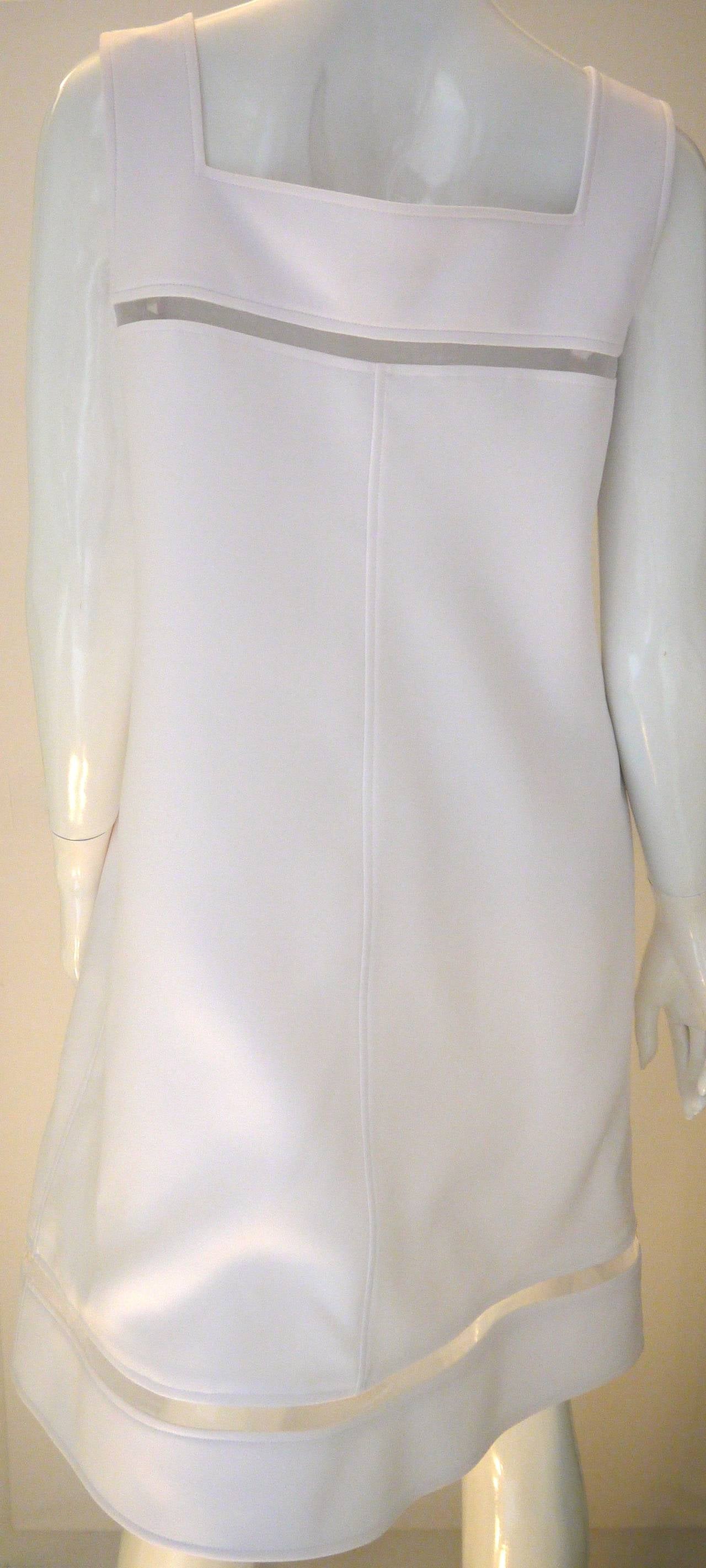 Courreges white cocktail dress with peek-a-boo mesh cross sections at the bust and at the bottom of the dress. Gorgeous white dress that is a size 44. Dress is 100% polyester and made in France. Fantastic dress for the avid Courreges fan or someone