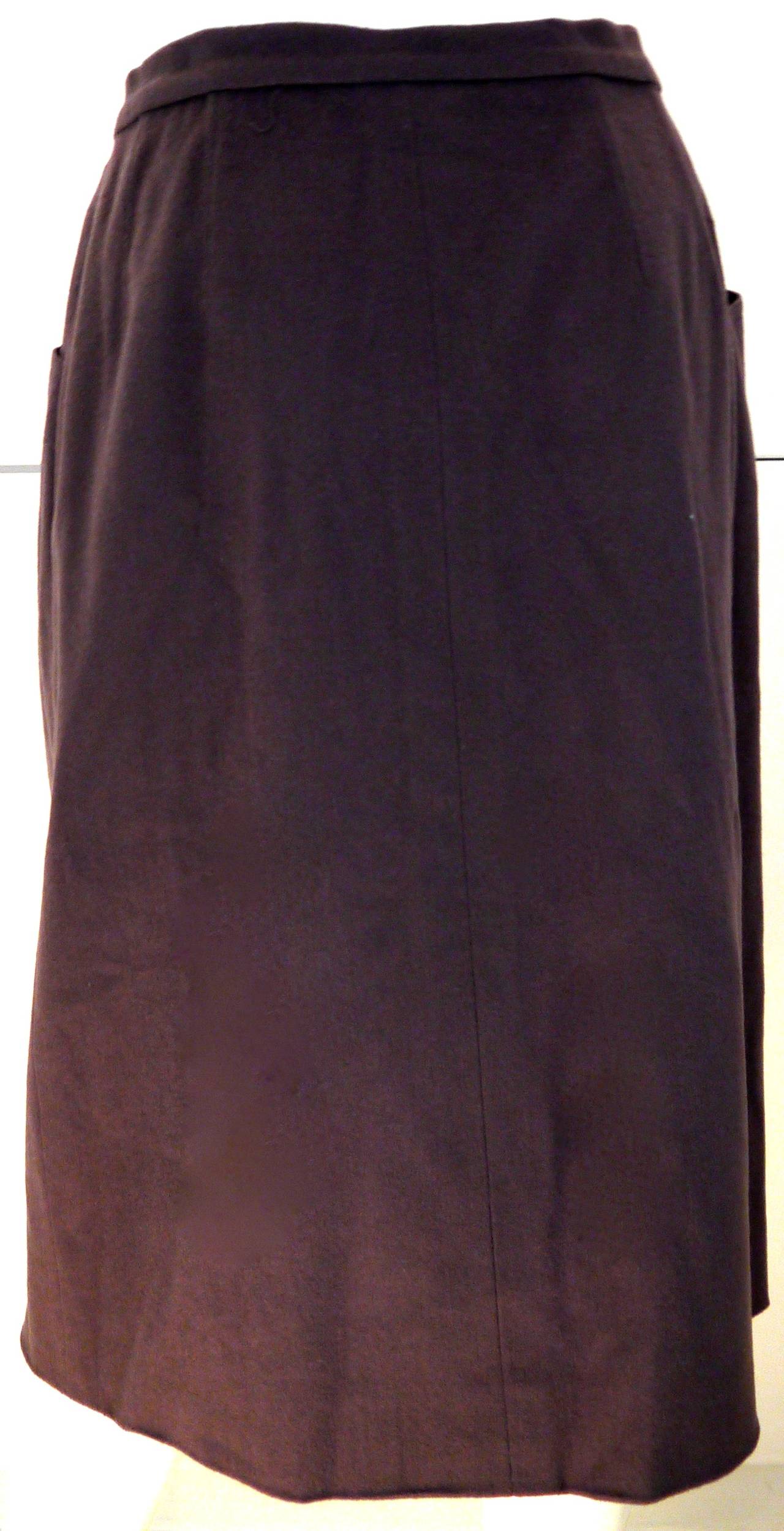 Presented here is a beautiful cashmere wool Chanel boutique ash brown skirt. Wool and cashmere blend that is lined in silk. There are two buttons at the top of the skirt with the iconic CC logo. With the 2 front buttons and pockets, there are easy