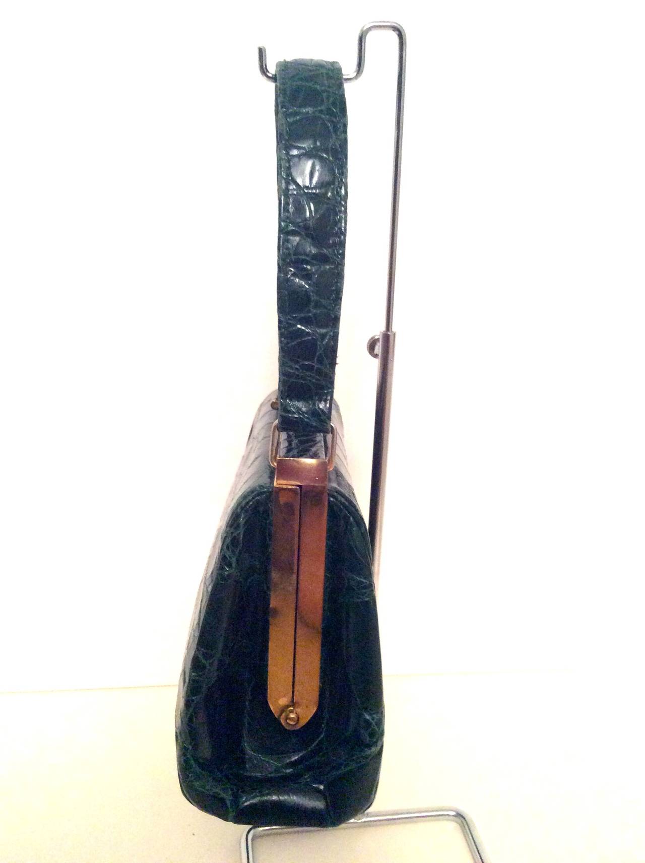 This beautiful Green Alligator purse is a true gem. It is with its original strap which is extremely rare for handbags from this era.  The bag measure 6.5 inches high and 9 inches wide at the bottom and 8 inches at the top of the bag. The strap is