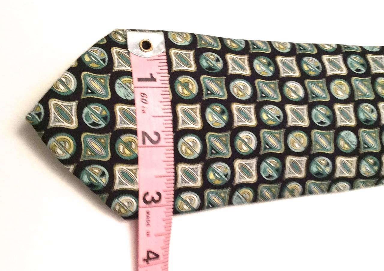 Emilio Pucci Silk Necktie that is varying shades of green, blue, and white in a pattern of Pucci designs along the length of the tie. Gorgeous designer tie which is a great addition to any personal wardrobe or tie collection.