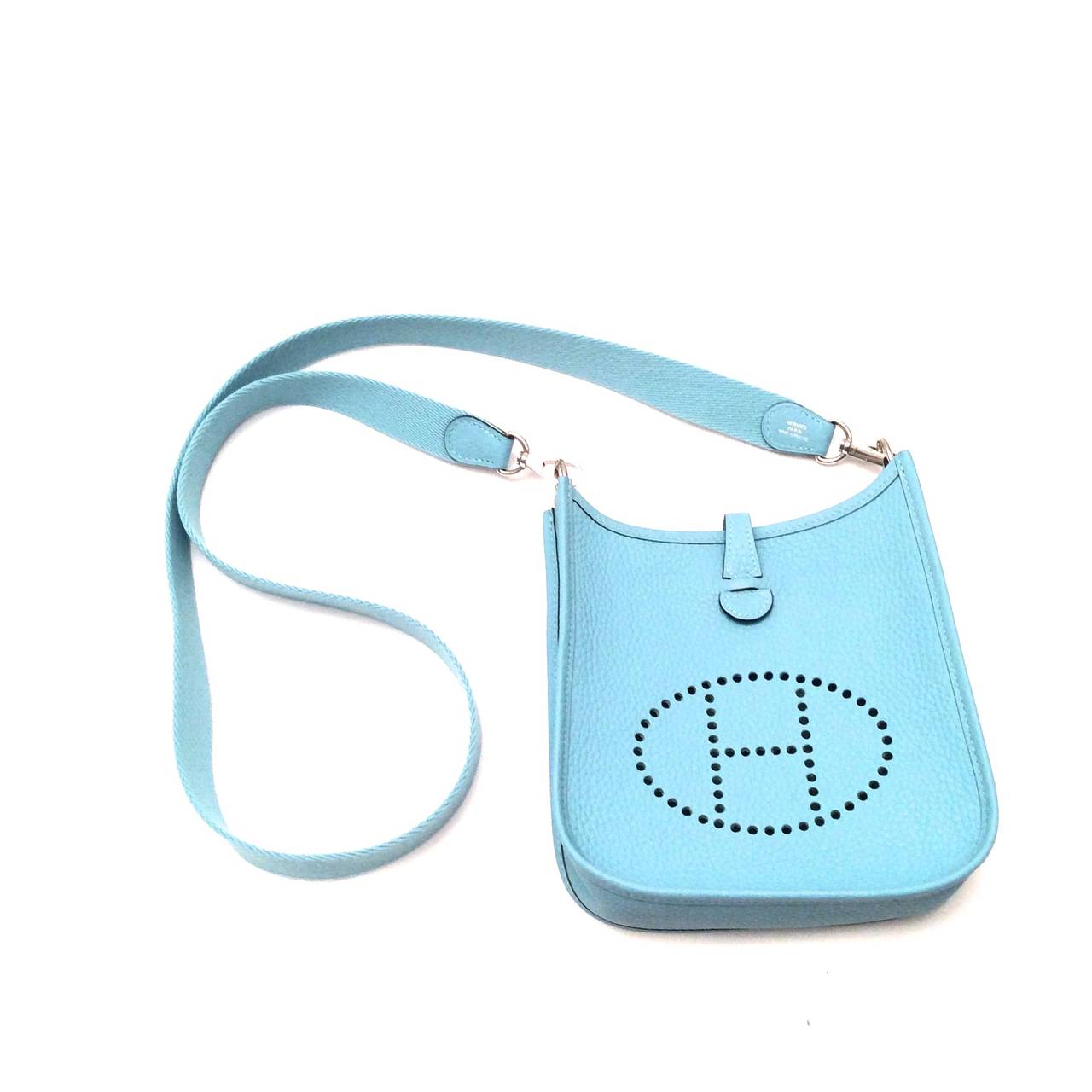 New mini Evelyne / Evelyn in original box. Gorgeous mini Evelyne in atoll bleu / blue. Great cross body bag that is perfect for all basic necessities. The leather on the bag is Clemence. There is a snap on the back of the handbag for opening and