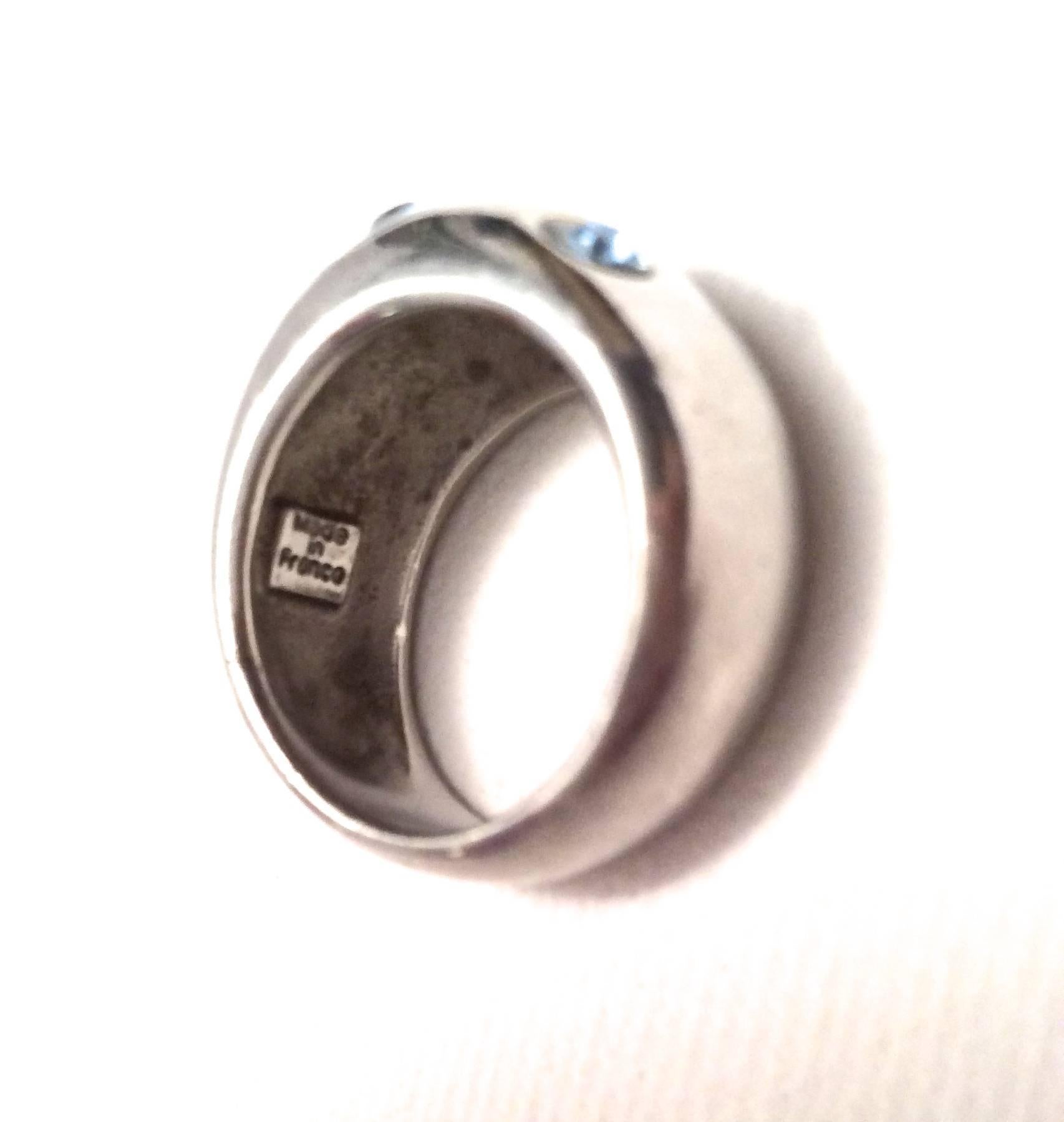 This is a lovely sterling silver Yves Saint Laurent ring in size 5.5. It is signed on the inside with the YSL logo. The ring is a dome shape which comprises 7 light blue colored Swarovski crystal stones. It is from the 1980's and is very unusual to