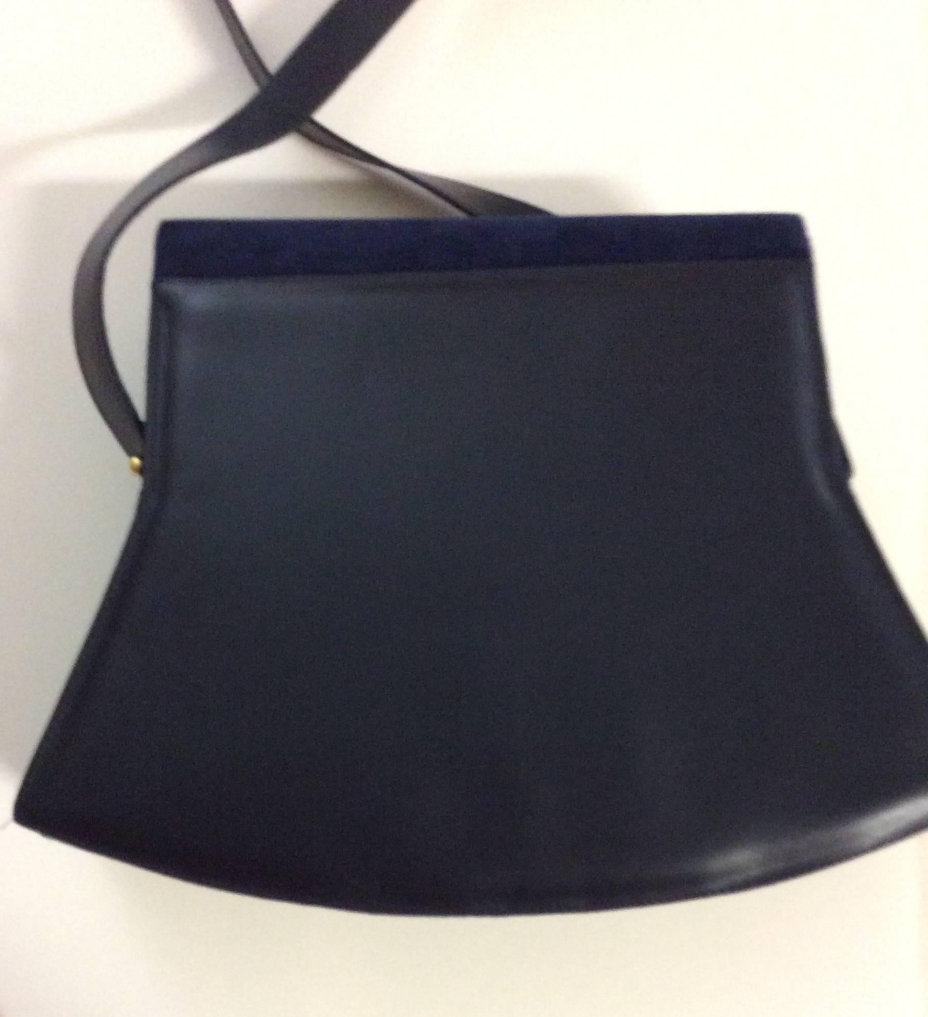 This Charles Jourdan handbag from the 1980's is new and has never been used. The bag has a lovely shape with the front being a navy blue suede and the back is a navy blue leather. There is one gold tone snap enclosure and a strap with two gold tone