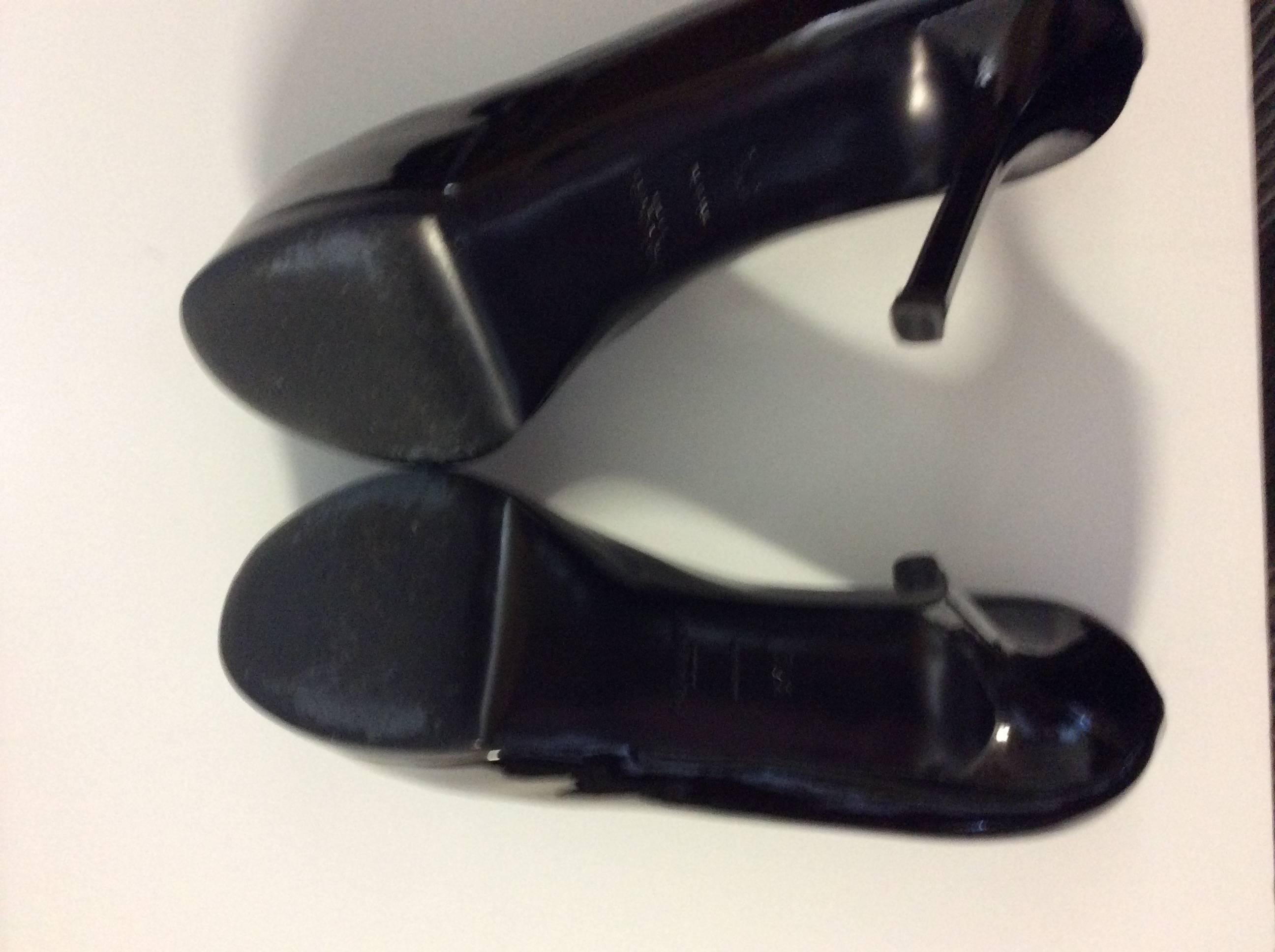 This striking pair of Yves Saint Laurent 37.5 black patent leather pumps are truly amazing and the Tribute model is known for its comfort!  Worn once for a runway show. There are no signs of use other than slight wear to the bottom of the sole. A