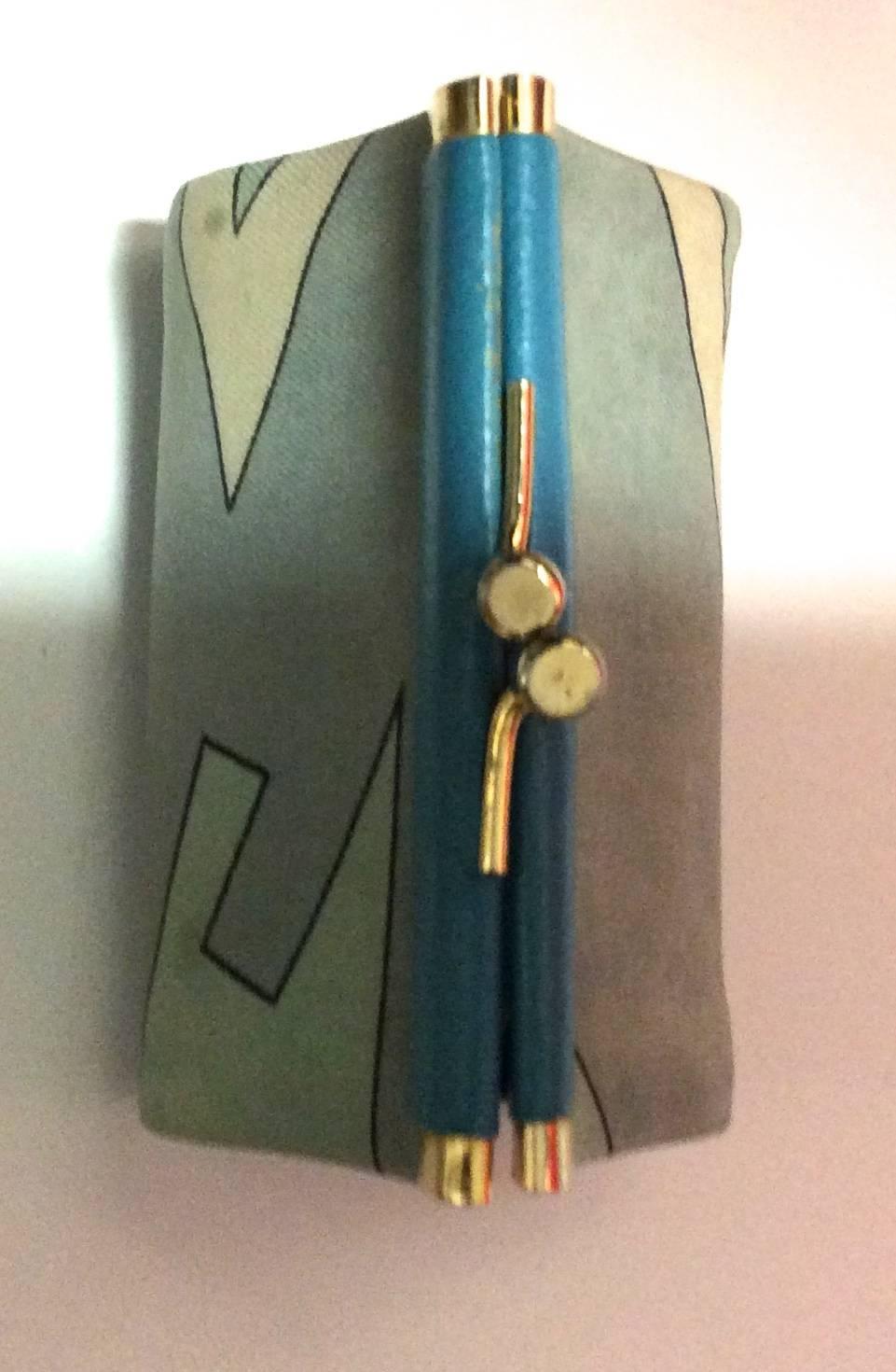 You are looking at a 1960's Emilio Pucci leather and silk coin purse. The change purse is in fair condition with fading to the silk. The teal blue leather trim on the center of both sides is in very nice condition and the snap enclosure is trimmed