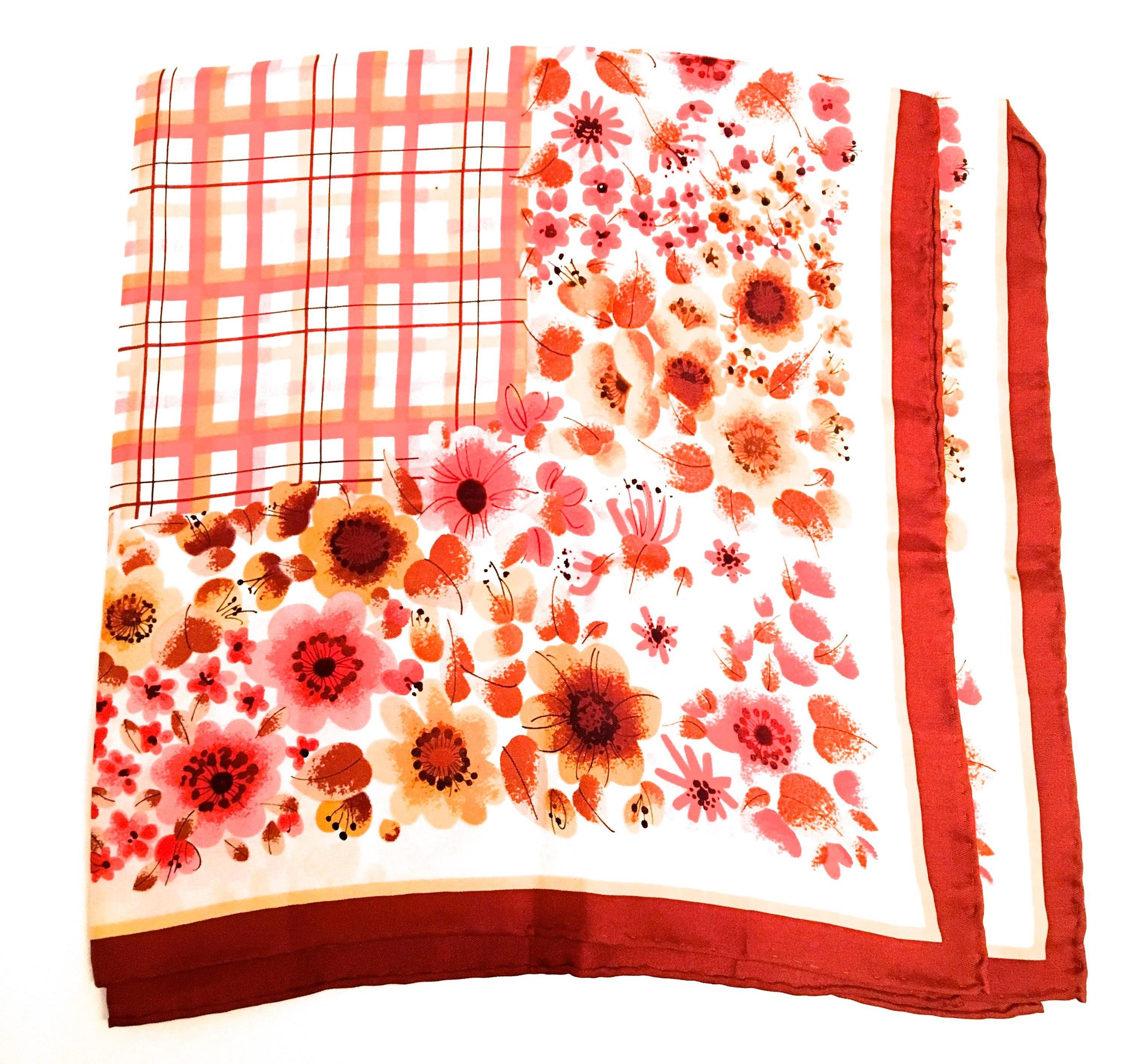 Presented here is a vintage scarf from Emanuel Ungaro. This beautiful hand rolled scarf is from the 1970's. It is comprised of a floral design with varying shades of red, brown, pink, yellow and black throughout. At the center of the scarf there is