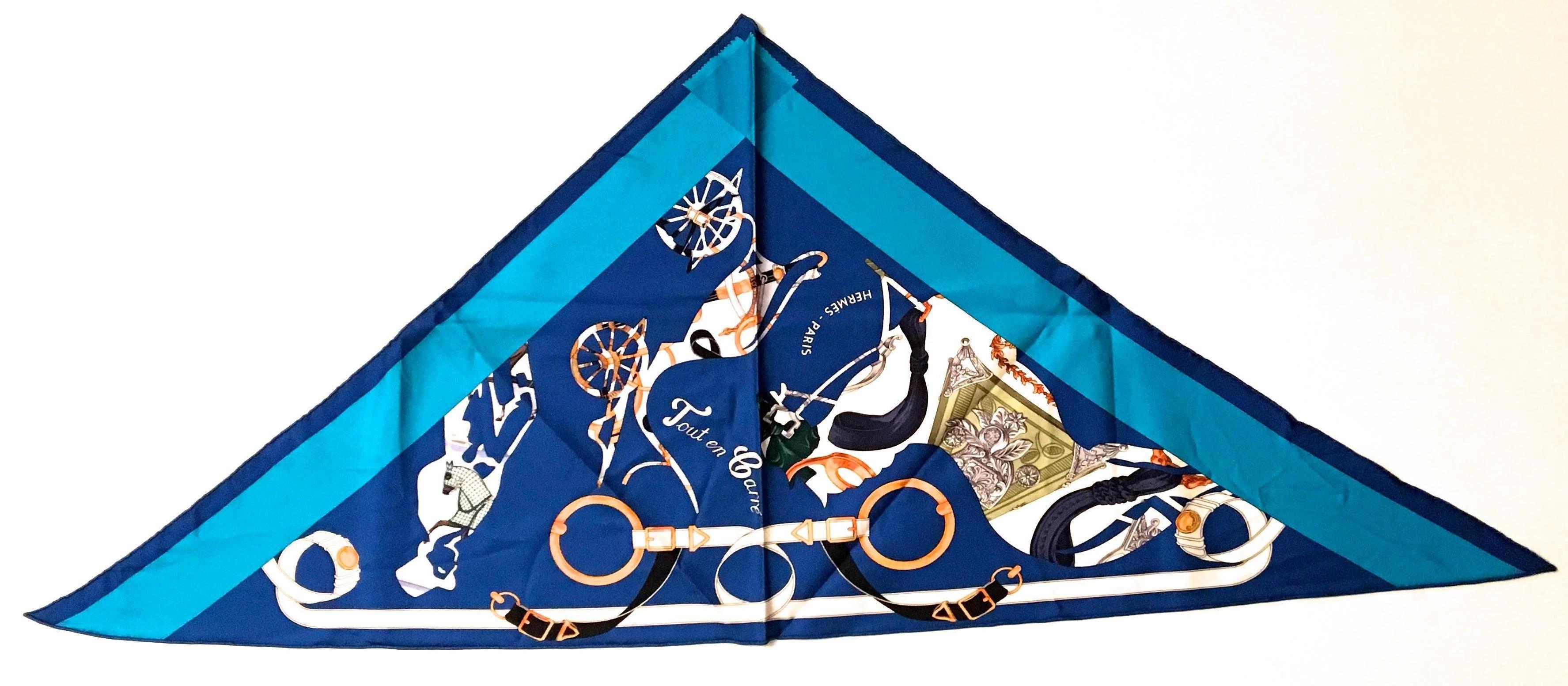 Presented here is an extremely rare scarf from Hermes Paris. This beautiful scarf is made from 100% silk and is hand rolled. The scarf is in a rare triangle shape. The design is comprised primarily of shades of blue with splashes of silver, gold and