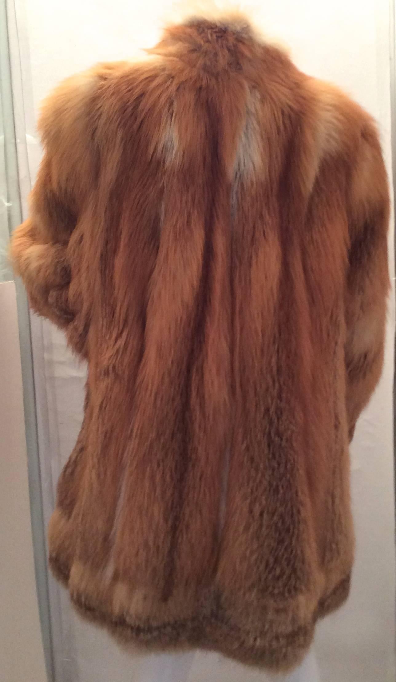 This magnificent mint condition red fox coat has been worn two times. This jacket is 10 years old. The jacket has one invisible snap closure in the front. It is lined in beautiful silk. The interior of the coat has two inches of brown suede before