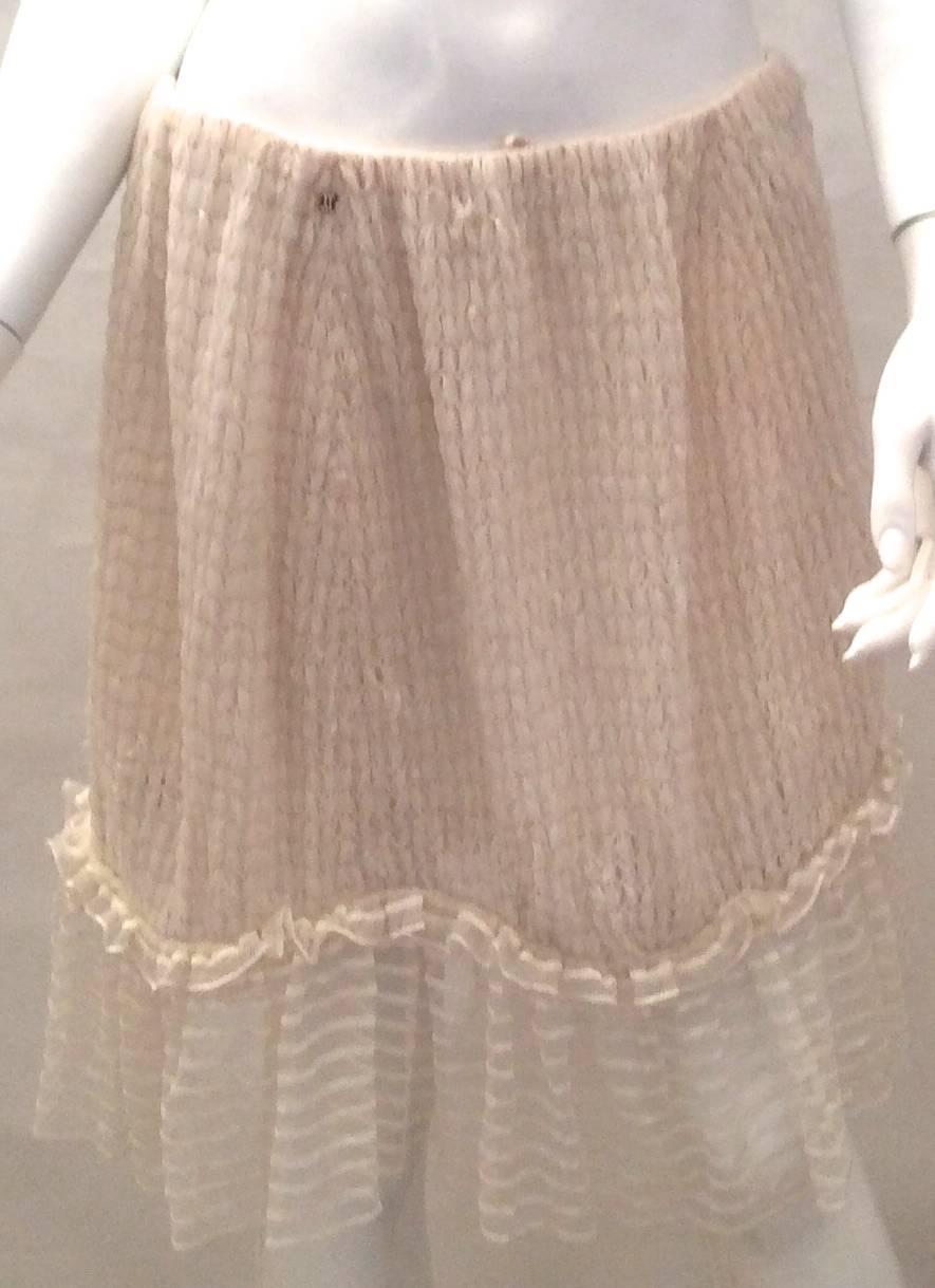 You are looking at a beautiful Chanel cocktail skirt in a size 42. It is a very interesting skirt because the top is made of gauze-type ribbon that is sewn throughout the skirt until it meets a mesh trim at the lower end of the skirt. The skirt is a