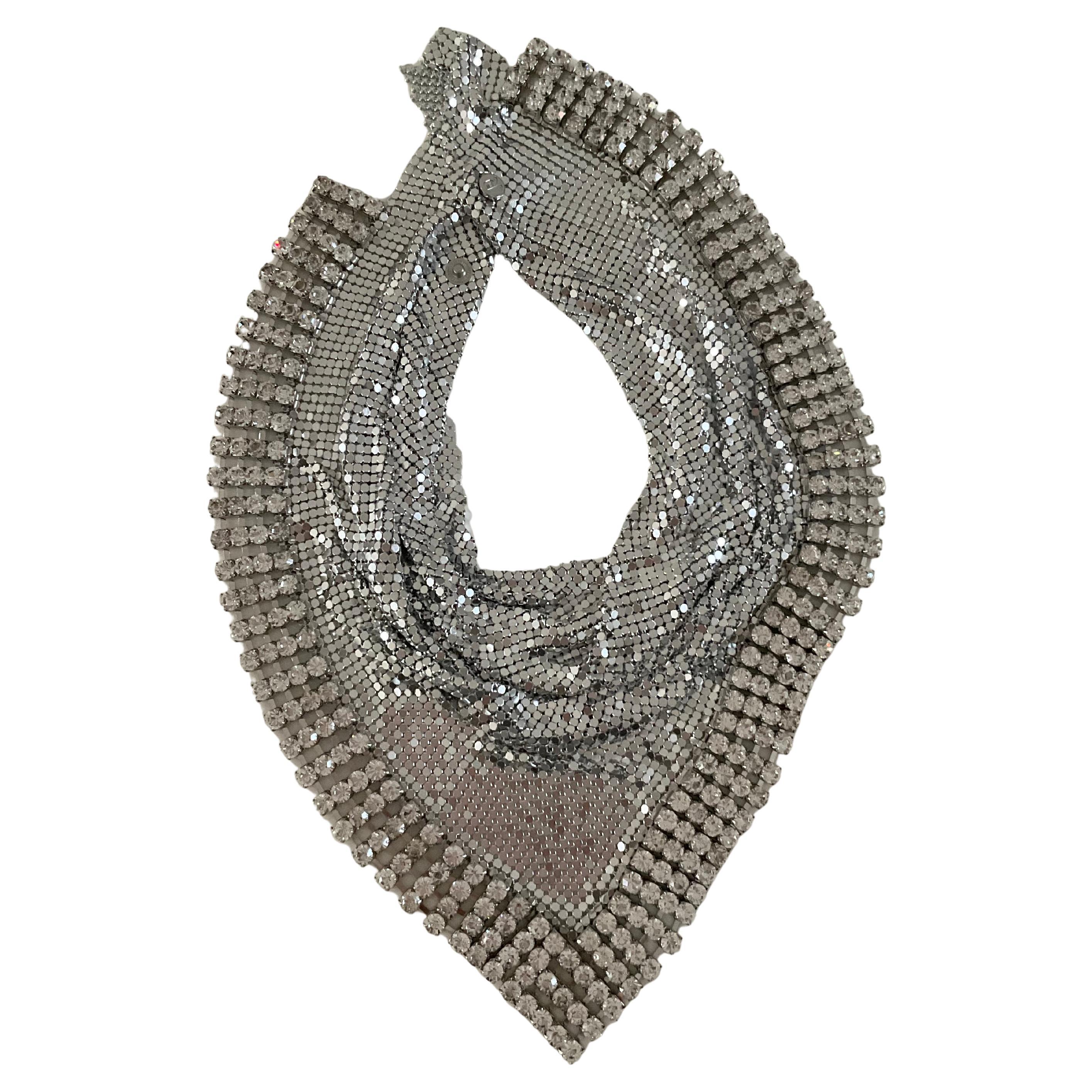 Esta obra maestra de edición limitada, un raro pañuelo triangular de malla metálica de H&M para Paco Rabanne, fusiona el arte futurista con la alta costura ponible, confeccionada con una brillante malla metálica adornada con pedrería, una