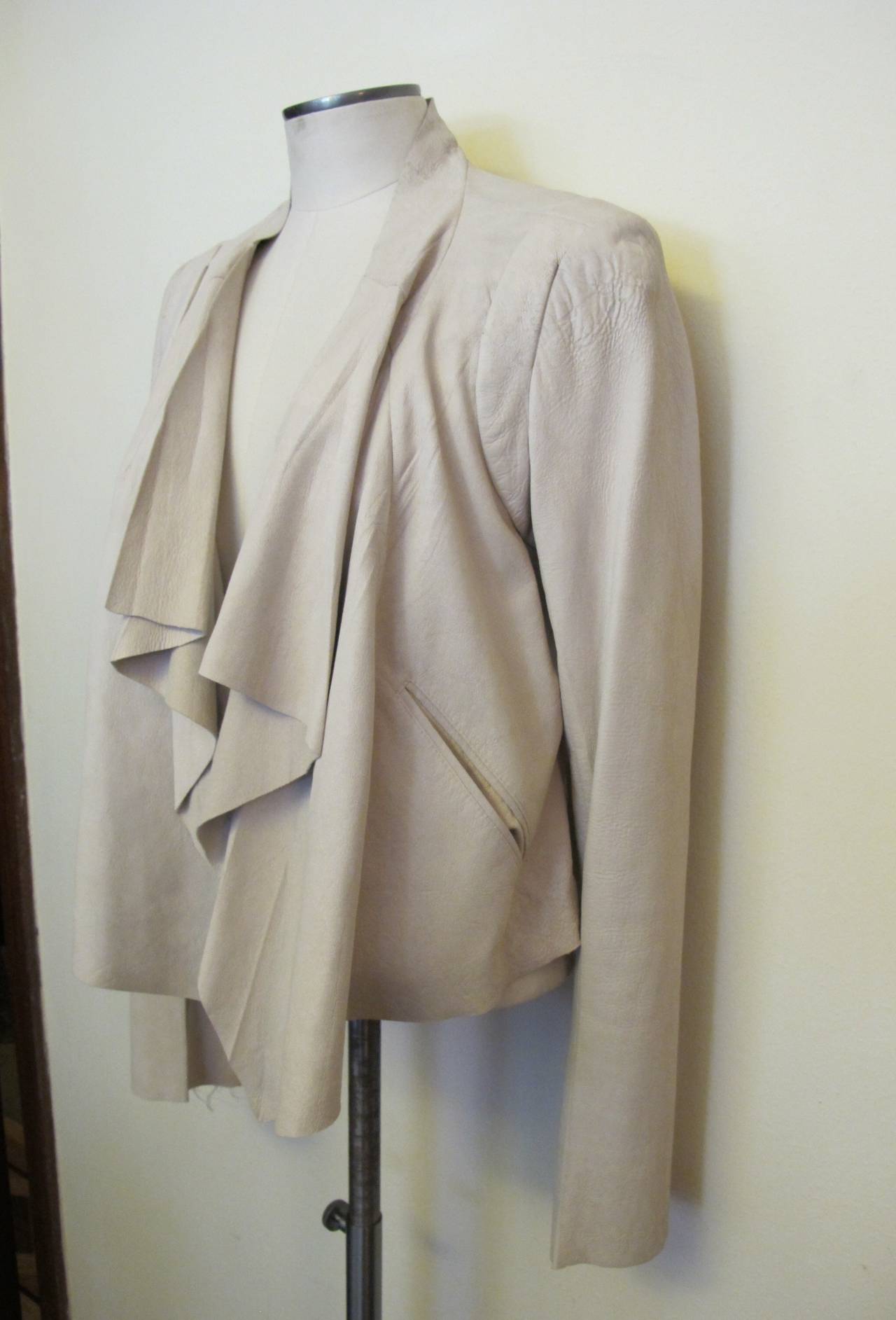Elegant, chic light sand sheep leather asymmetrical jacket. It fits like a dream. The panels of the jacket cascade artfully down the front of the body. Back of the jacket measures 18 inches long. Longest part of jacket measures 23.5 inches. Sleeve