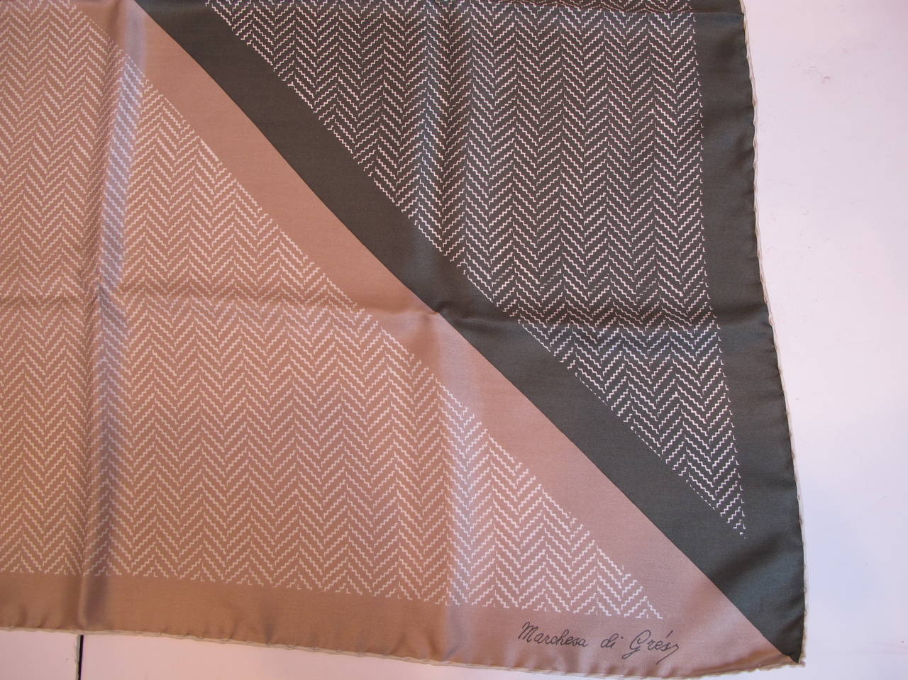 This pure silk scarf has provenance of a famous San Francisco Interior Designer. The hem is hand rolled. The colors of taupe and army green create an elegant background fro Chevron design. The Marchesa di Gres company reigned from 1950's to 1984.