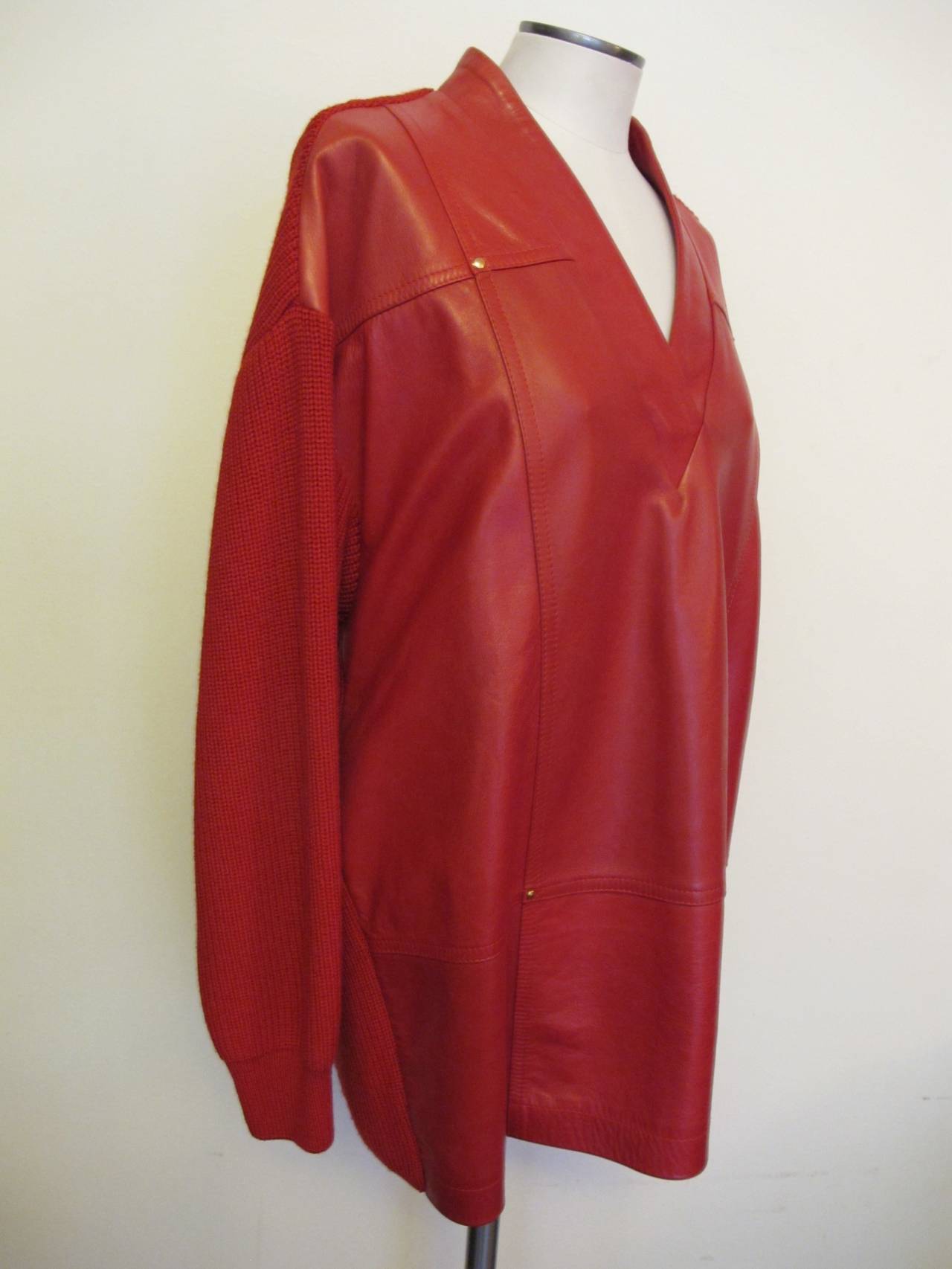 Fabulous luscious red leather pull-over sweater with thick knit on sleeves and back of sweater. Two gold studs serve as decorative pieces on the front of the jacket. The jacket is marked US Size 4 and is obviously mis-marked. The Statement piece is