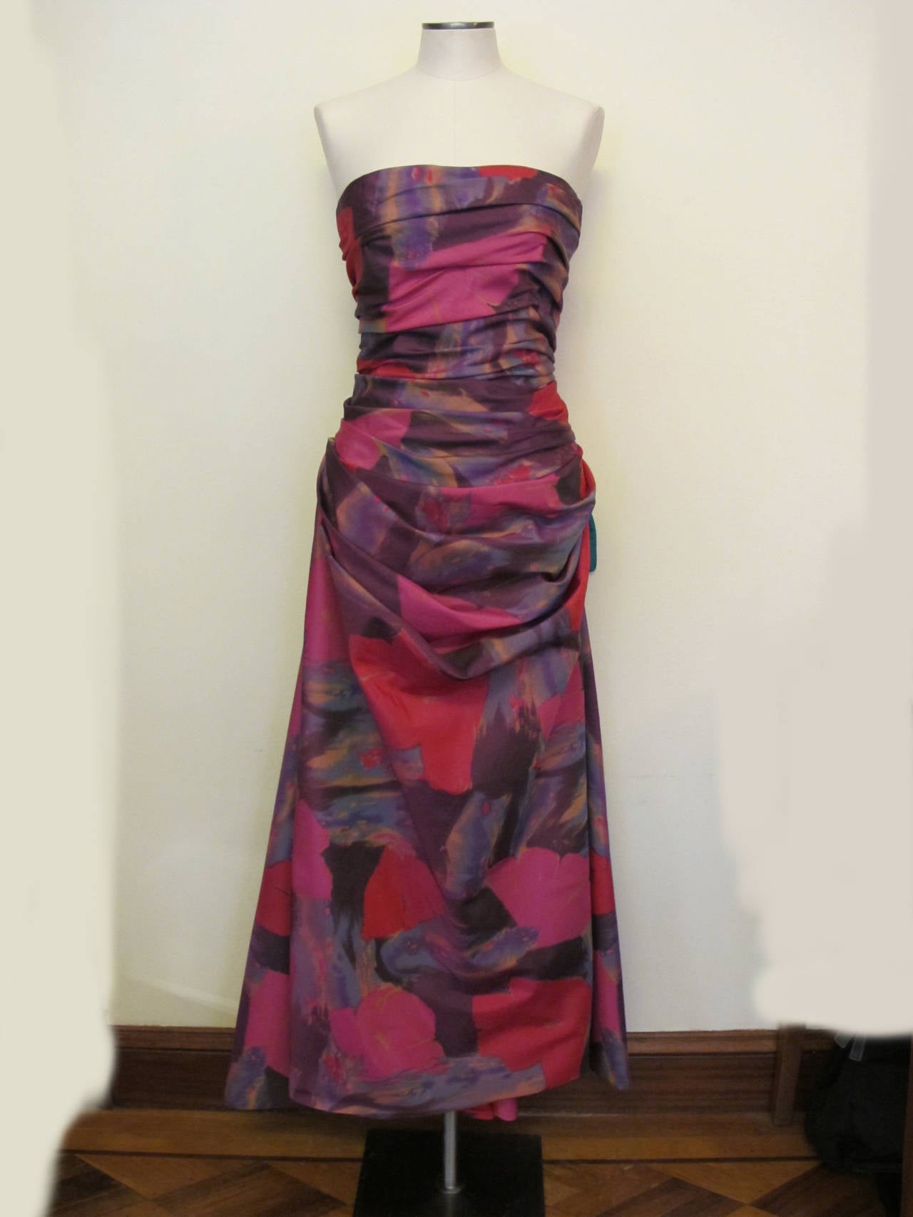 The amazing scope of Bob Mackie fashion is captured in this silk taffeta floral evening gown. Each layer is gathered in the front and forms a lush draping effect.. The colors of the flowers are fuchsia, royal purple, crimson red with small touches