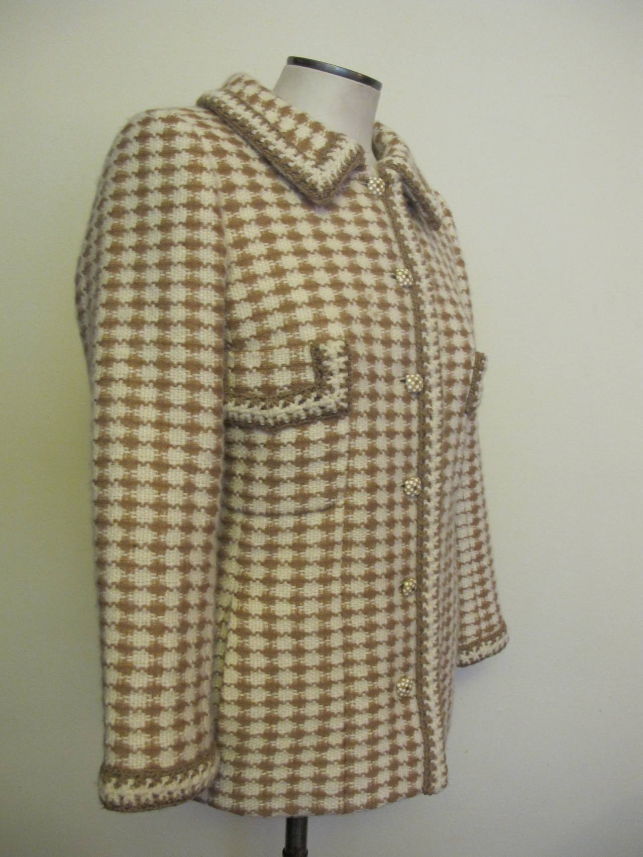 Unusual, Chic and elegant camel and white Houndstooth checkered jacket has two pockets below breast and two pockets on side of hips. Six Chanel buttons with logo and polka dots are highlights of the pristine piece. Collar, breast pockets and trim on