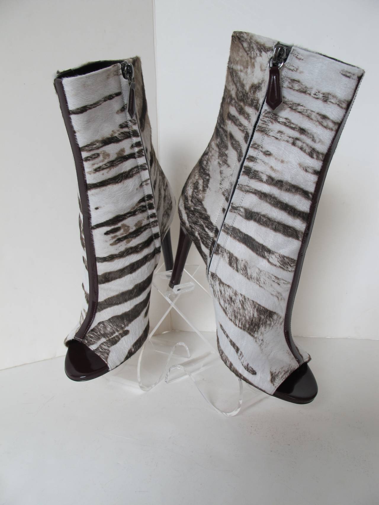 Dramatic Reed Krakoff Peeptoe Zebra Bootie with deep Cordovan Patent Leather Stripe Cascading down front and Cordovan heel. The Zebra design is so chic. Heel measures 3.25 inches. Heel is entirely covered around it with the Cordovan patent leather.