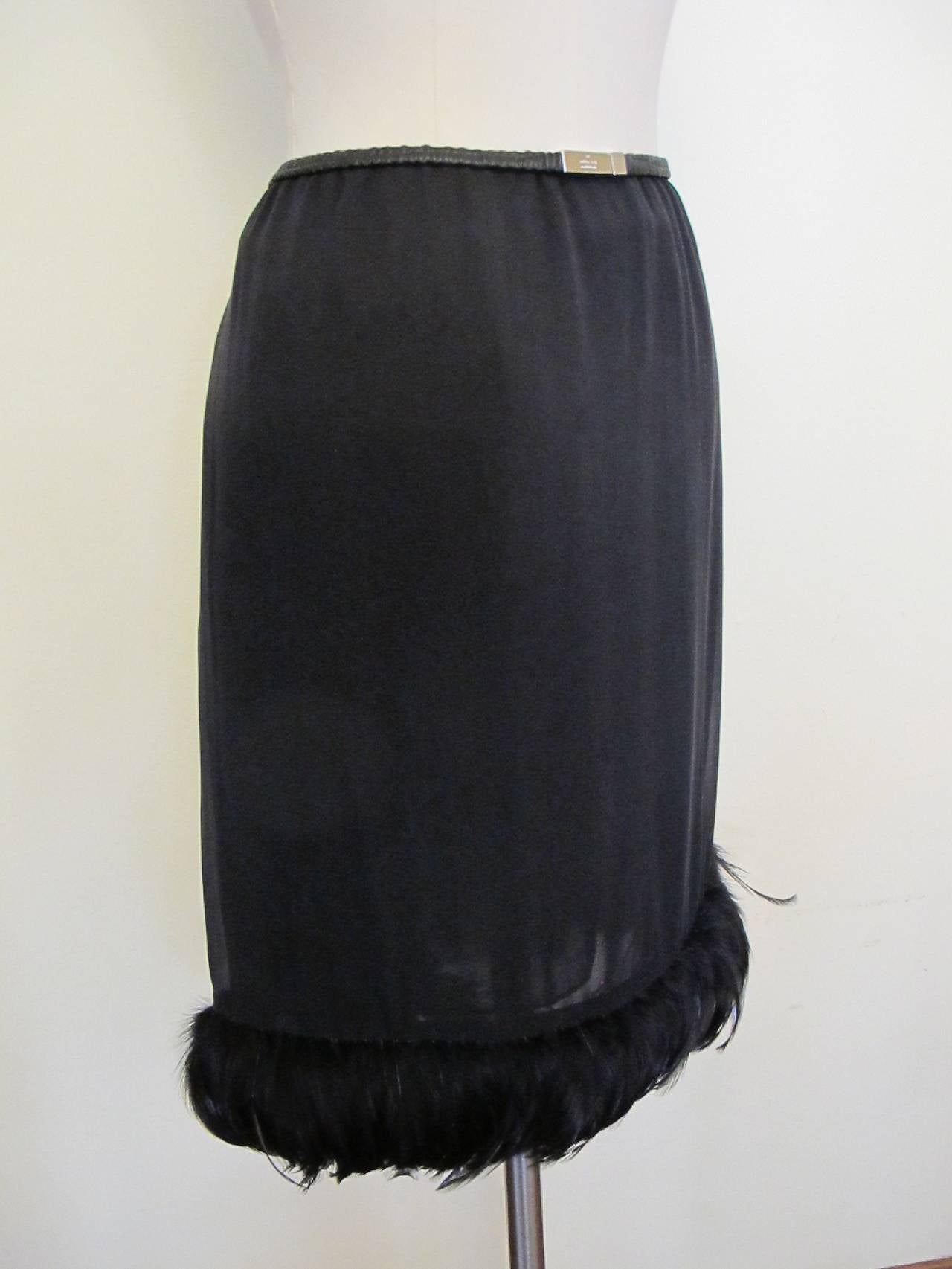 Charming silk skirt with leather elastic at waist and a feathered trim at bottom. Because of the elasticity at the waist, the skirt will fit a larger size than 40.  The elasticized waist stretches from 30 to 36.