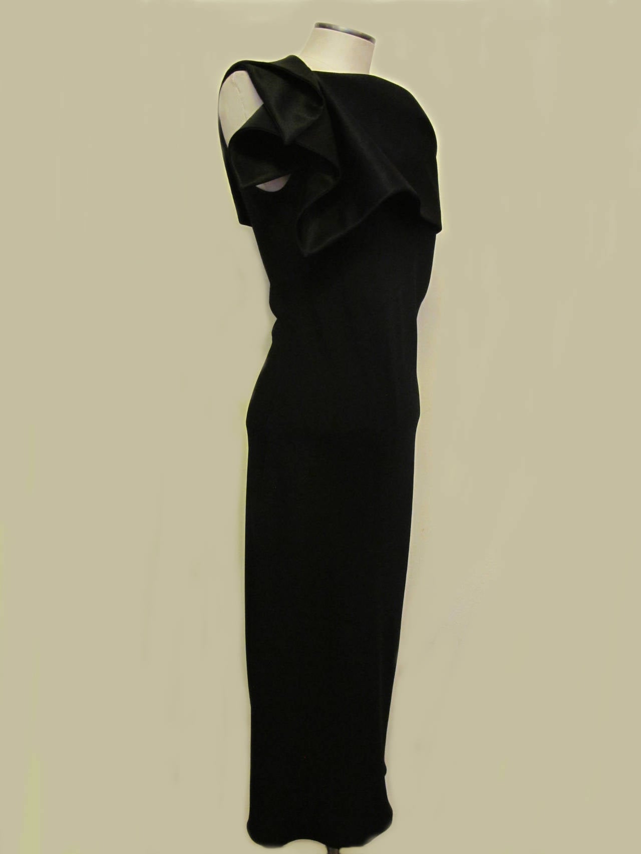 This elegant black asymmetrical black cocktail dress is beyond chic. It is cut on the bias with no waist and hugs the body in heavenly ways. There is a drop shoulder on the left side. The top of the dress is shiny silk and the rest of the dress is