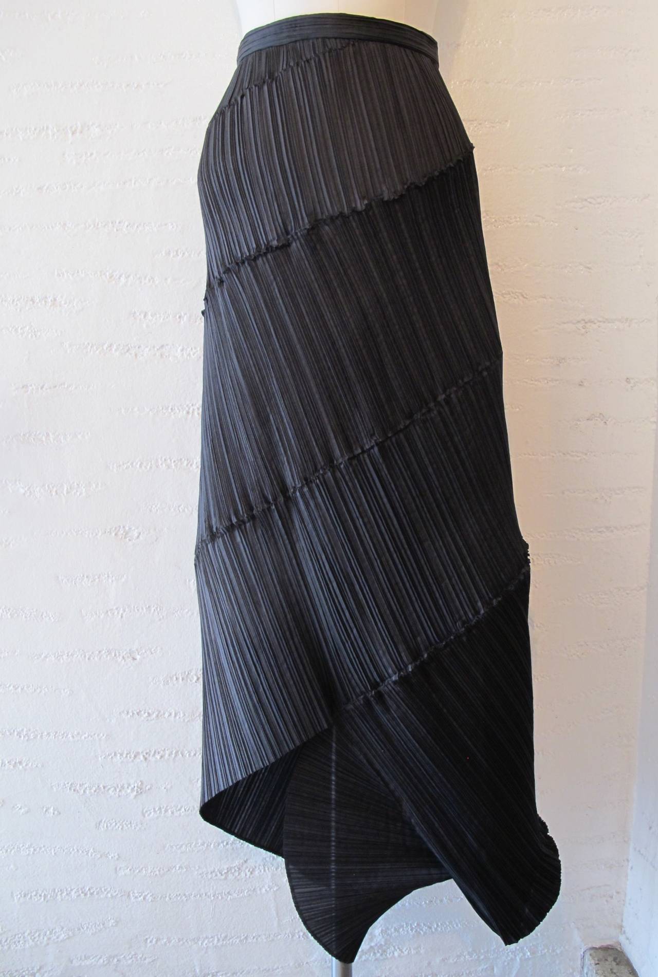 The DNA of this fabulous asymmetric black skirt is freedom of movement and the shape of the human form. The intertwining of the pleats is genius. When worn, it is striking and the stretch of the iconic pleats contours to the body highlighting its