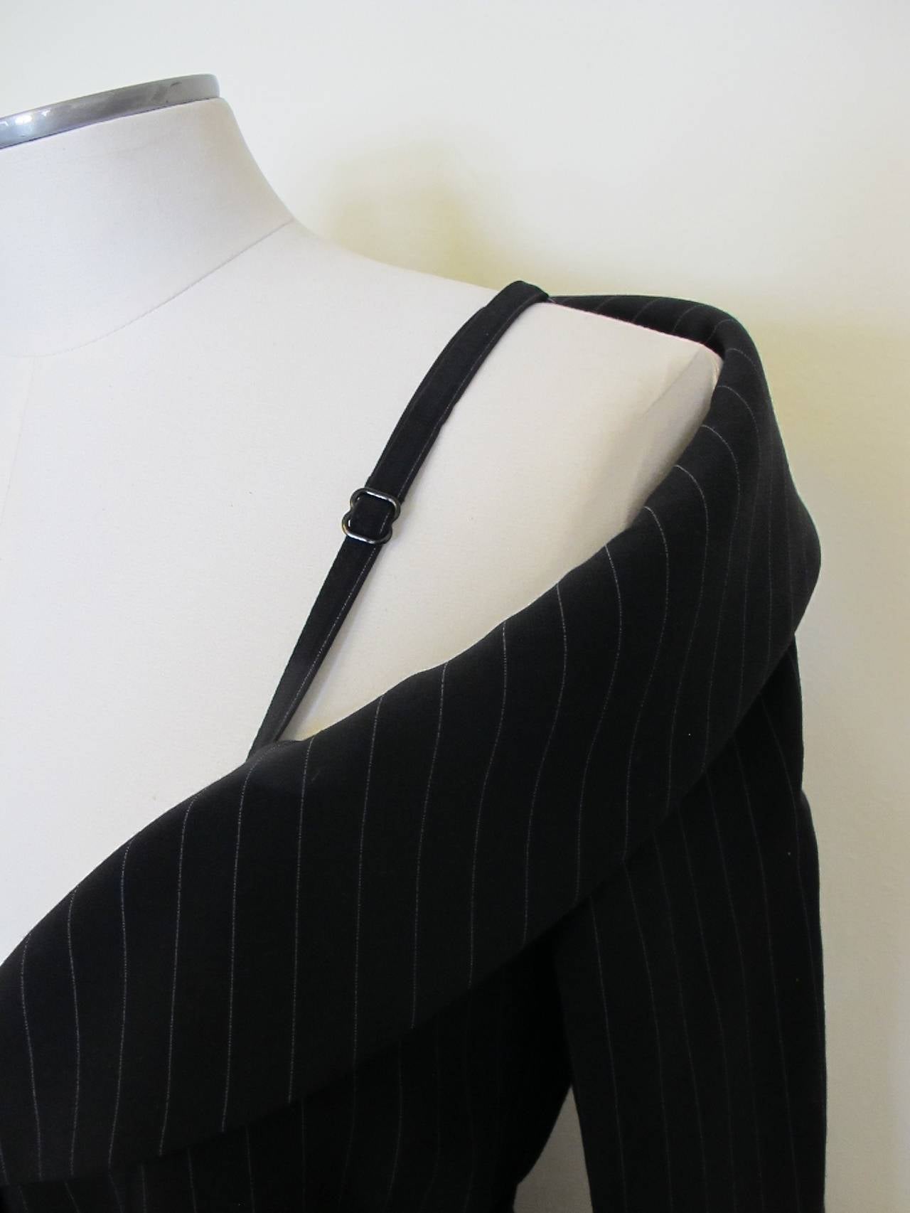 New from Neiman Marcus: chic Jean Paul Gaultier black dress with silver grey pinstripe and matching belt which is 2 inches wide by 61 inches long. The dress is a straight cut: Gaultier cleverly has inverted a corset bra strap which is adjustable on