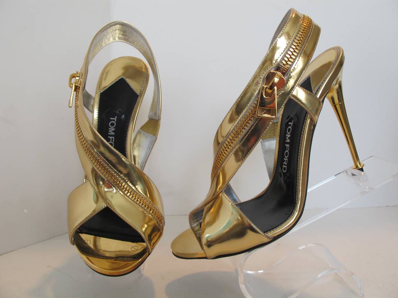 Tom Ford Gold Sling Back Sandal with Wrap Around Zipper is perfect for day or evening. There is a 1.375 inch metal piece with two inset screws at the toe. Heel measures 4.5 inches.