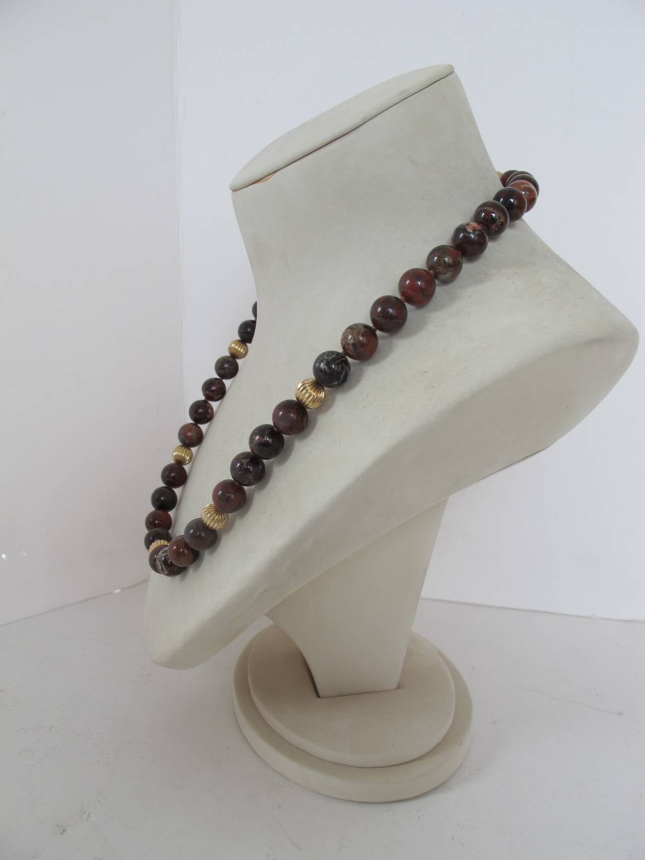 Elegant 1980's Agate Necklace with 40 agate stones and 5 gold ones. Clasp is marked Sterling Silver and Agate stone encased by gold surrounds the clasp. The Agate stones measure 1.2 cm wide. The gold ones measure 1 cm wide.