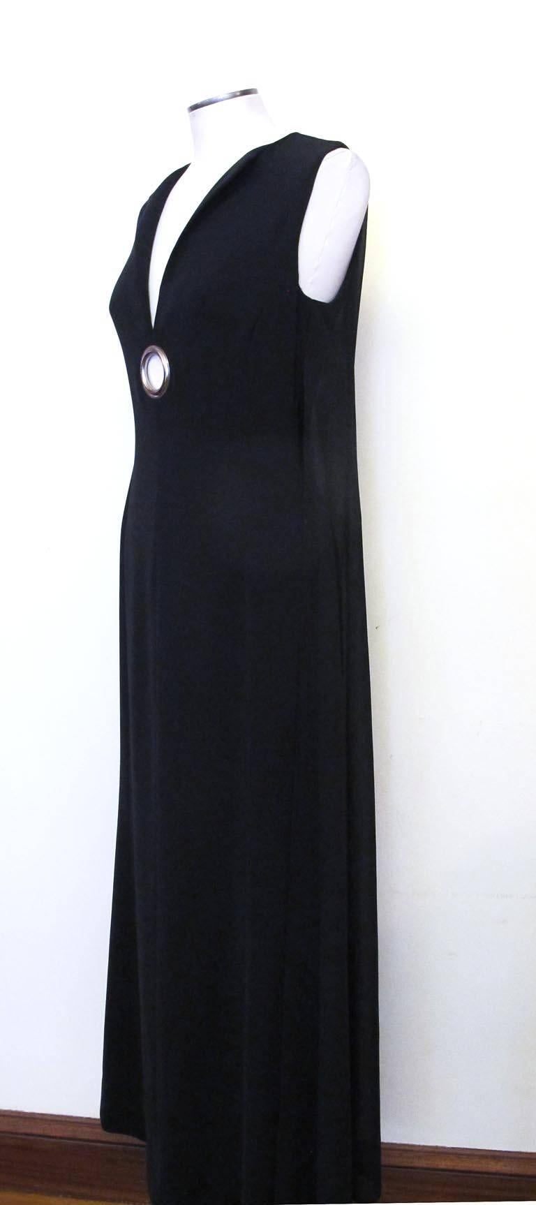 This vintage Paco Rabanne sleeveless black evening gown has two fabulous sheer panels attached to the back and drop to the floor, plus an open silver-tone metal ring at the bottom of the V-shaped neck line. The panels flow freely as one walks and