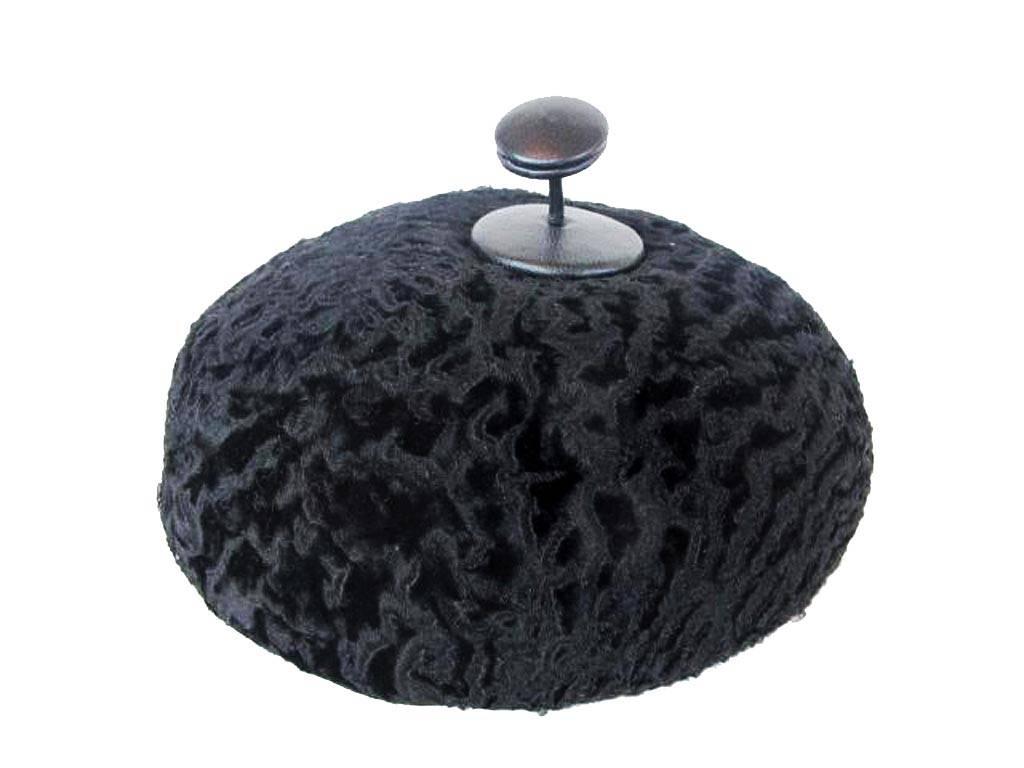 1960's Black broadtail beret with leather button on movable swivel on top. Hattie Carnegie was born in Vienna, Austria (1889-1956). Through the decades, her hats and clothes were worn by movie stars. After her death, her legacy lived on. The