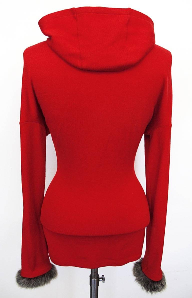 This Yohji Yamamoto hooded red sweater has a drop shoulder and detachable faux fur cuffs. The hood highlights the entire face. The piece is in excellent condition.

YOUR PURCHASE BENEFITS THOSE WHO ARE DEVELOPMENTALLY DISABLED.