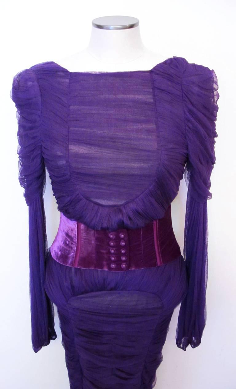 This new 2010 Tom Ford purple cocktail dress is a hand ruched silk chiffon sheath style with long flowing bishop sleeves, accented with ruched draped shoulders. It features an open oval back, narrow velvet waistband and side zipper closure. The