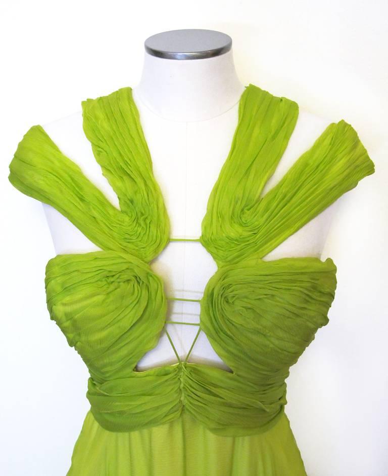 Gorgeous Emanuel Ungaro chartreuse green silk chiffon evening gown. The gown is Grecian influenced with a halter style bodice that is ruched with cut-outs and has a built in bra. The skirt is full with a 29 inch slit up the front and a short train