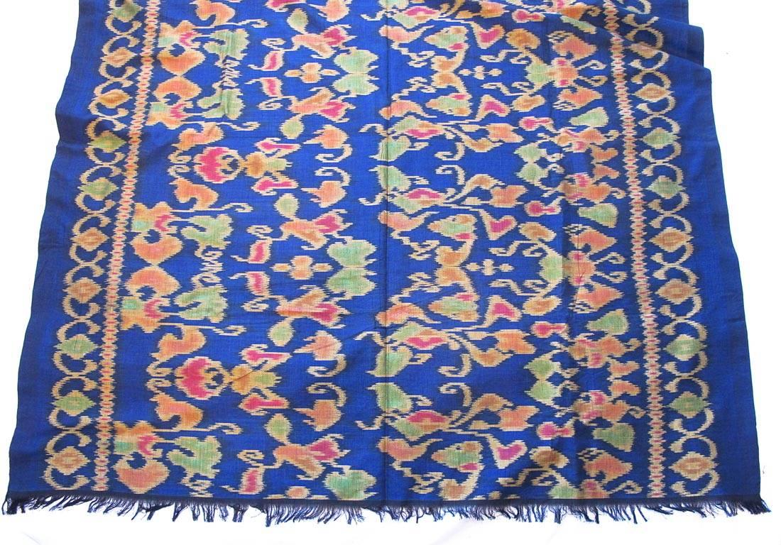 Vintage 1950's batik inspired ethnic print scarf/wrap in the tones of blue, red, green and gold. 100% raw silk with fringed borders. From the estate of a Grande  Dame of San Francisco.

YOUR PURCHASE BENEFITS THOSE WHO ARE DEVELOPMENTALLY DISABLED.