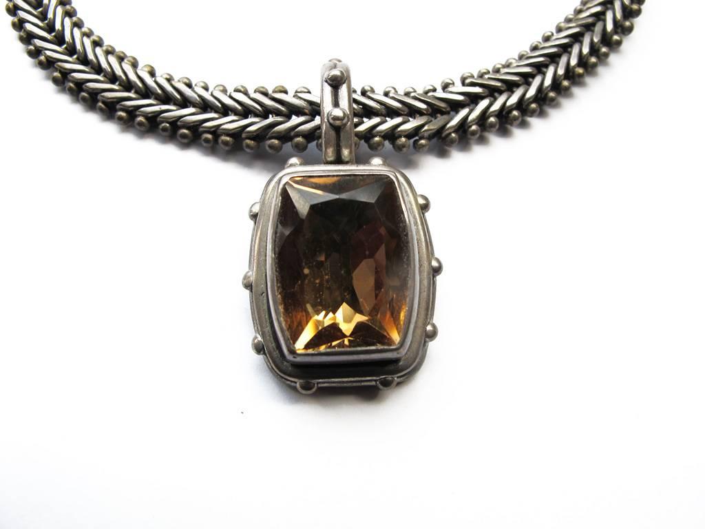 This vintage 1980's sterling silver chain necklace is in a fishtail design and has a pendant with a smokey quartz stone. The piece is by the renowned Brooklyn-based jewelry designer Stephen Dweck. It is signed and stamped sterling.

YOUR PURCHASE