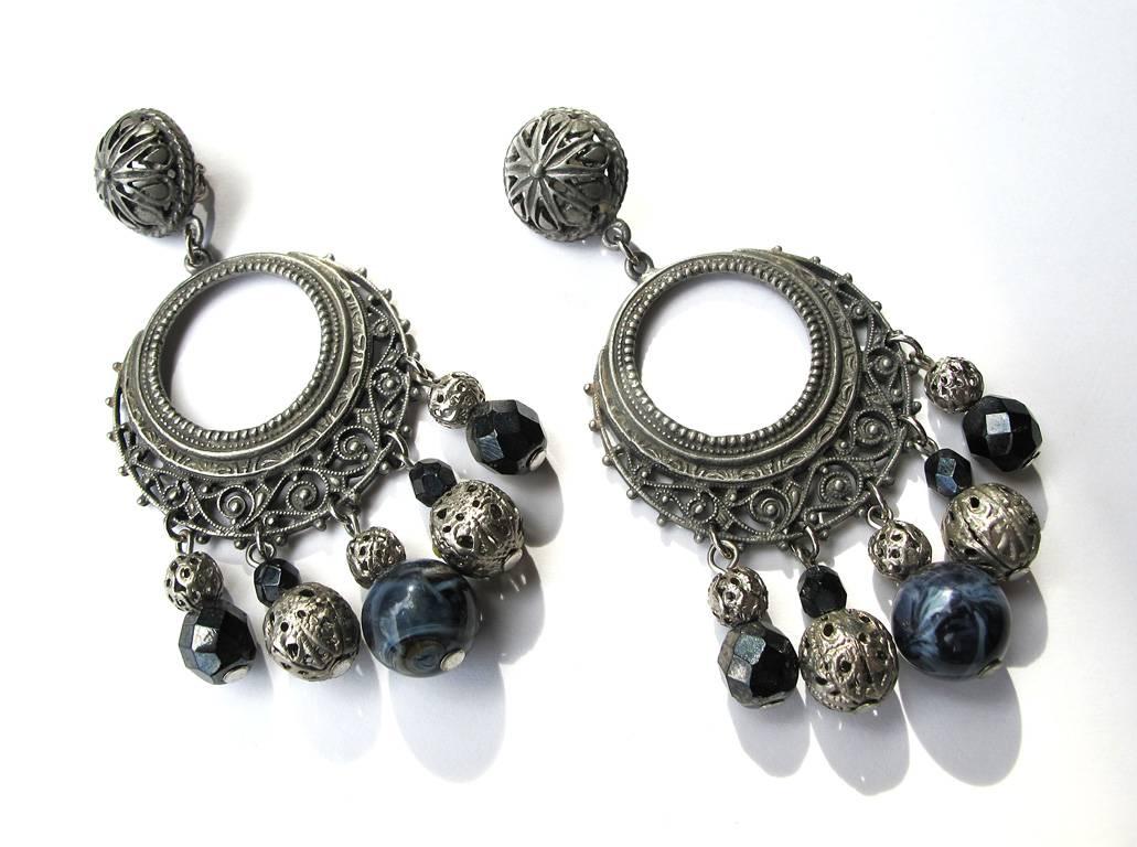 Vintage 1978 silver-tone filigree clip drop earring in an ethic design with jet black faceted crystal beads. Designed by Isaac Manevitz who founded Ben-Amun in 1977. Hallmarked on back side.

YOUR PURCHASE BENEFITS THOSE WHO ARE DEVELOPMENTALLY