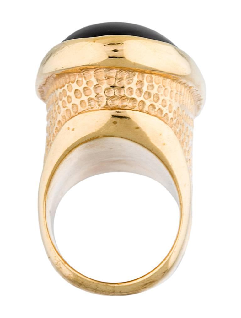 Statement Gold-tone Tom Ford cocktail ring featuring black oval resin cabochon with textured dot accents throughout shank.

Metal Type: Gold-Toned Metal
Signature: Tom Ford
Metal Finish: High Polish, Textured
Size: 9
Measurements: Band Width