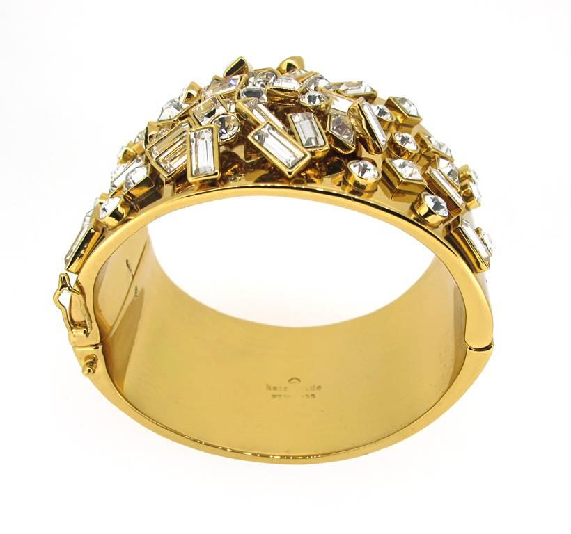 Whimsical Kate Spade chunky gold-plated bangle traces the wrist in scattered glass stones. Gold plate/glass. Hinge closure. 2.25" Diameter, 1.5" wide.