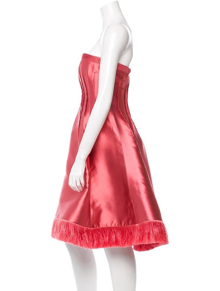 Beautiful pink silk Chado Ralph Rucci strapless cocktail dress with seam details throughout, fringe accent at hem and zip closure at left back.

Fabric: 100% Silk
Measurements: Bust 30", Waist 28", Hips 42", Length 33"