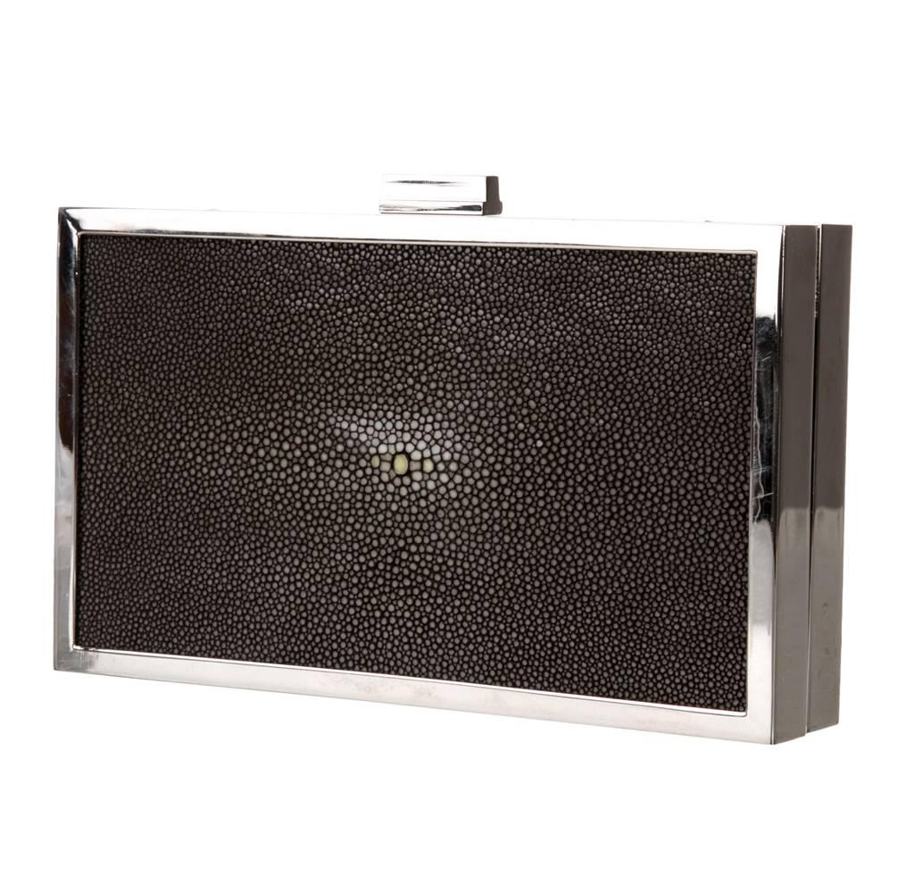 Black stingray Calvin Klein Collection box clutch with silver-tone hardware, optional top handle, grey suede interior lining, single pocket at interior wall and push-lock closure at top. 

Measurements: Handle Drop 6.5", Height 5", Width