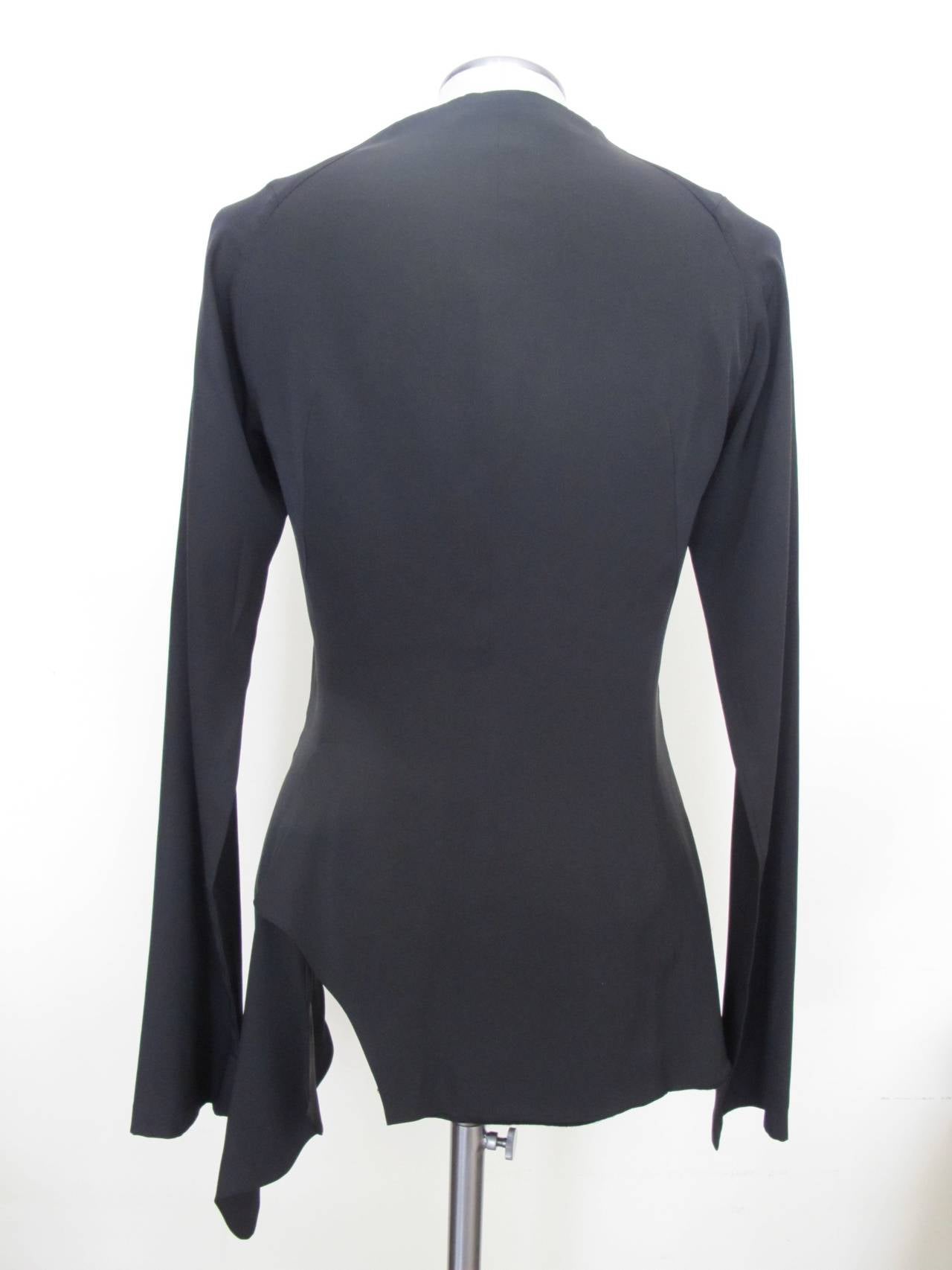This creation of Yohji Yamamoto has raglin sleeves. It has the unique touch of one pocket which is hidden in the chic draping. The pocket has great depth. It is silk and lined with 100% soft wool. The longest part of the jacket measures 31 inches in