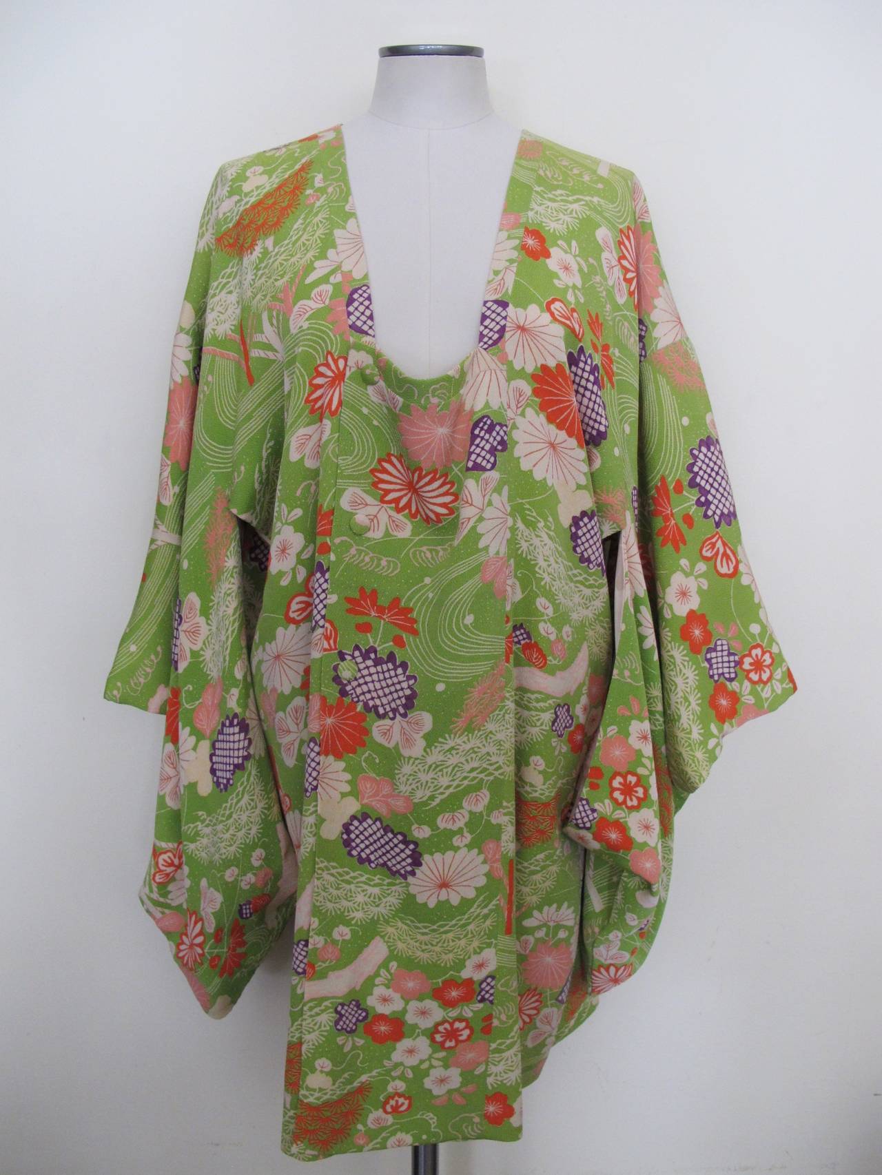 This perfectly designed 1950's Japanese Kimono Jacket was given to our charity from the estate of a San Francisco Grand Dame. The design is highlighted with a variety of cherry blossoms, trees and rivers. The colors are vibrant and include lime