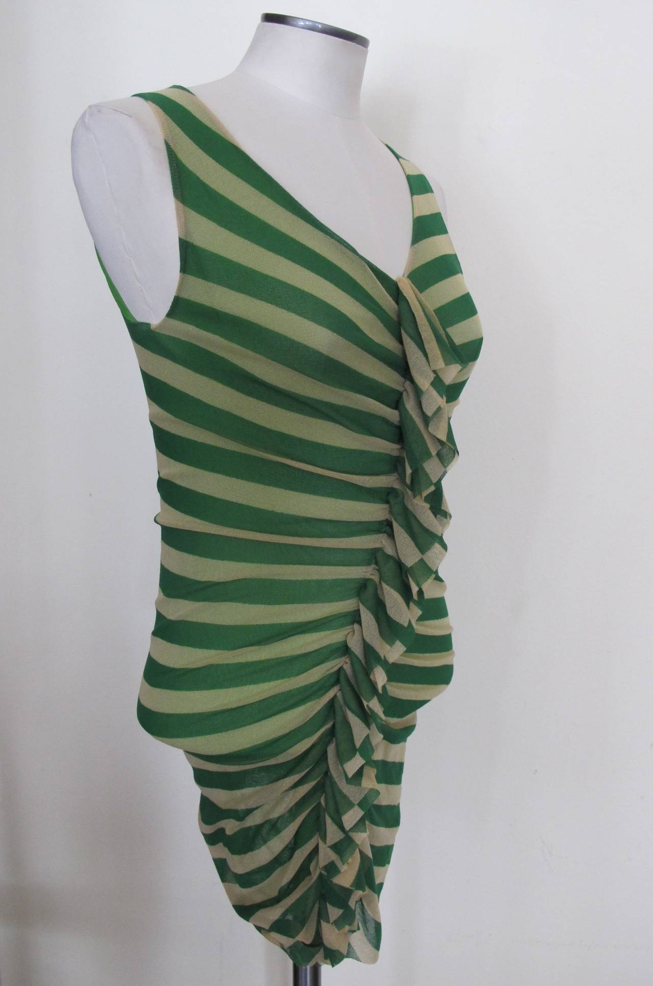 This chic, iconic Jean Paul Gaultier may be worn during the day or in the evening. The emerald green color is rich and the beige and emerald stripes and cascading ruffle lend the pice to make a statement. As in many of the Gaultier pieces the fabric