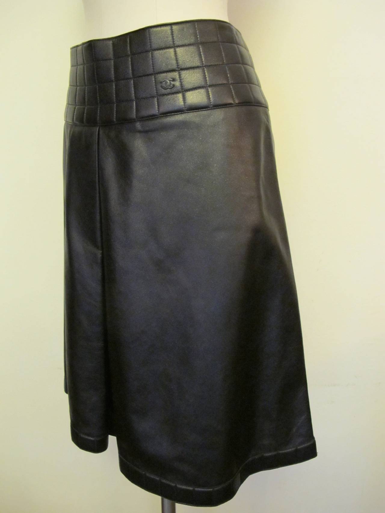 This Chanel Hipster Lambskin Skirt has a 4 inch quilted band around waist and a 1 inch quilted band surrounds the bottom of the skirt. The Chanel Logo appears on the waistband. Fall 2002.