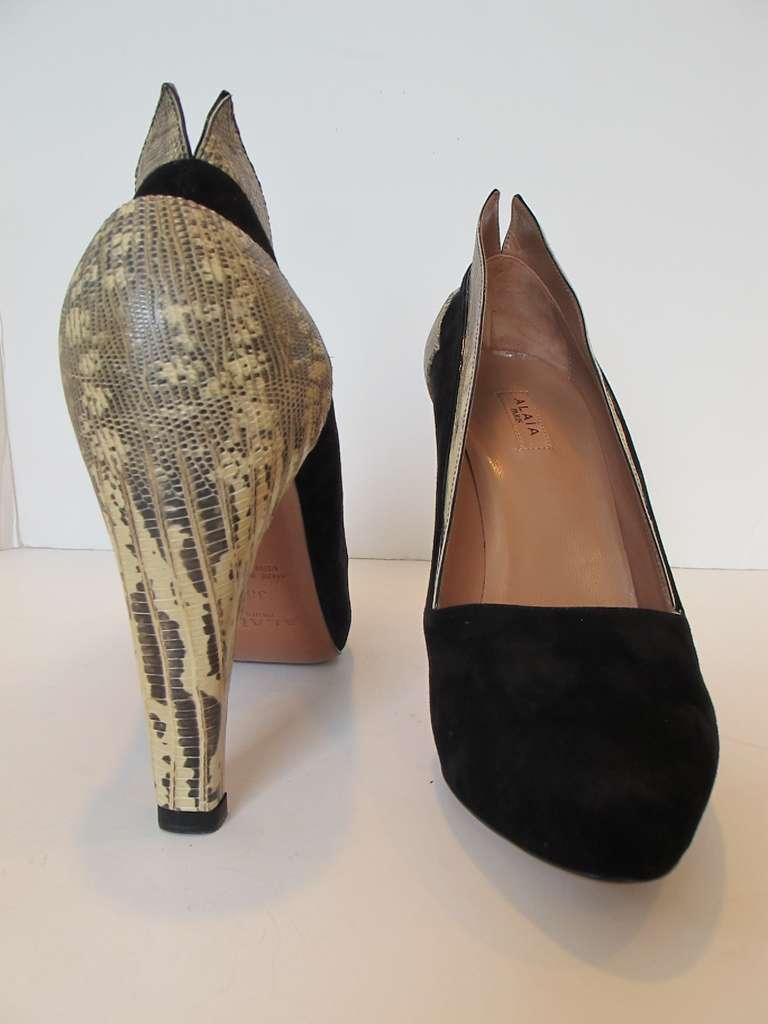 Classic, chic, new Alaia black suede and ring lizard pumps with 3.5 inch heel ring lizard on sides of shoes culminate in V shaped revealing slit in back of shoe.  New with original box. Size 38 EU. Original Price 1,989.00. Helpers House of Couture