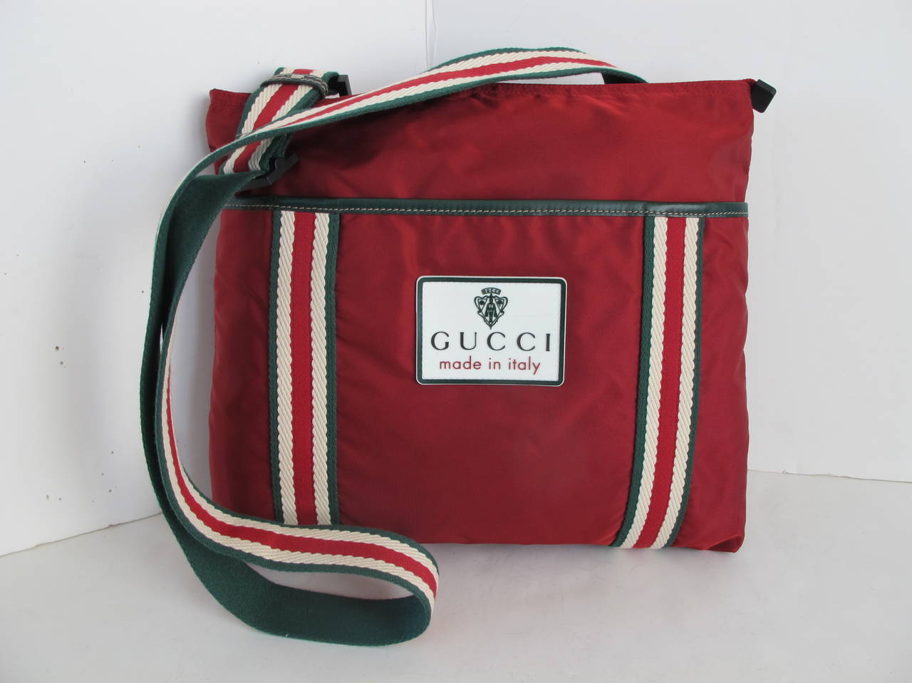 The rare 1970's Gucci Cross-bag was donated to Helpers. The vintage maroon bag has Gucci's signature hunter green, maroon and cream adjustable strap.

The original tags are safely put in pocket within bag. It has 2 pockets inside bag. Shoulder