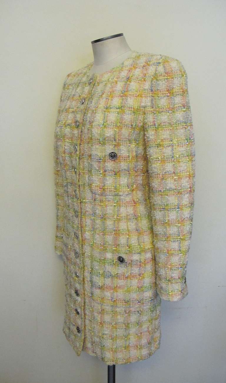 Chic multi pastel colored coat: yellow, pink, powder blue, lime green and white. The coat has accents of silver chanel buttons on the front of coat. There are four pockets and a silver button adorns each pocket. There are three buttons on each