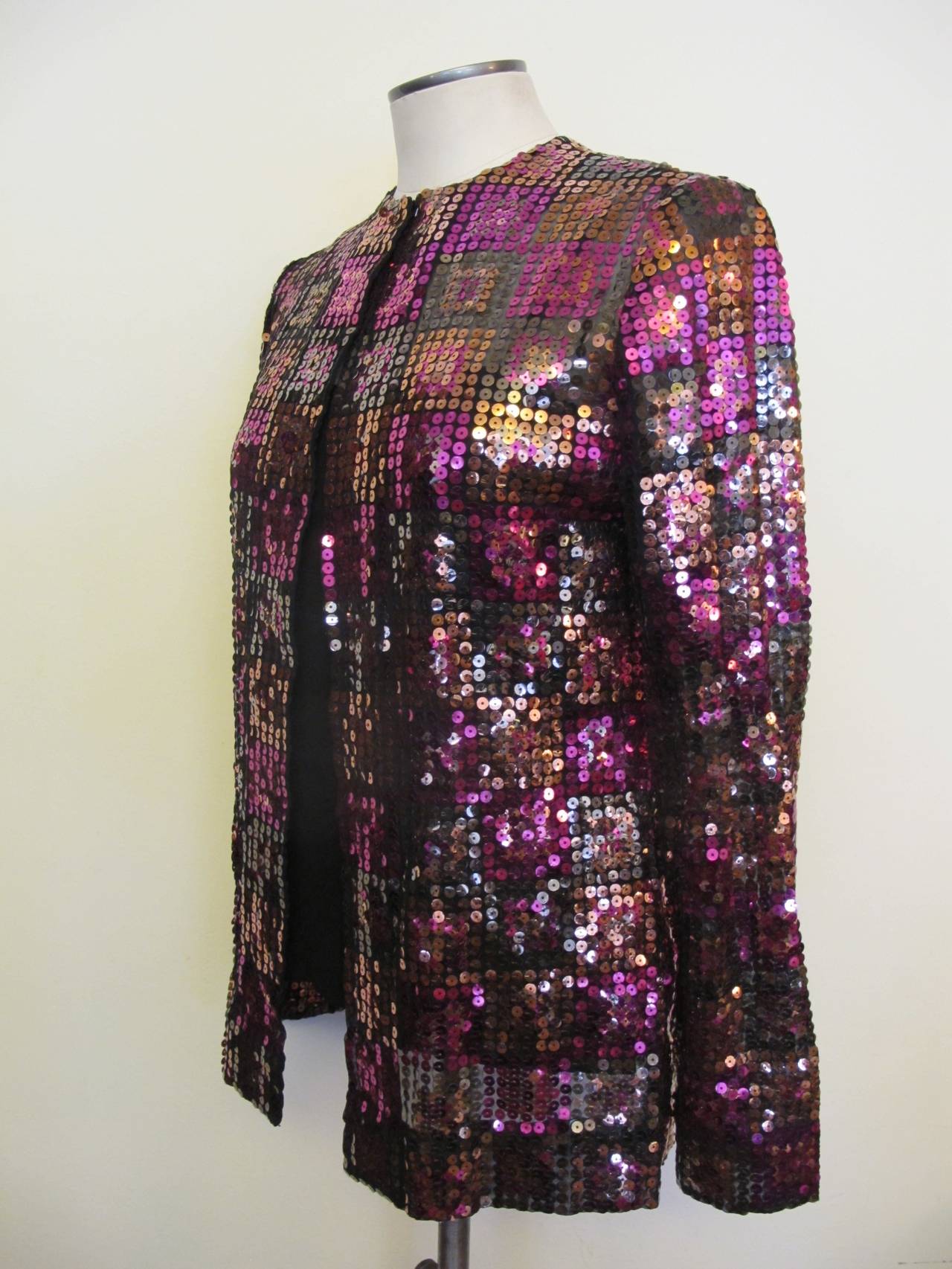 Collectable Adolfo Saks Fifth Avenue Sequin Jacket with closed neck. The sequin colors are pewter, copper and fuchsia. Adolfo was a special gentleman who cherished his clients and his clients adored him.

Shoulder to shoulder measures 14 inches.